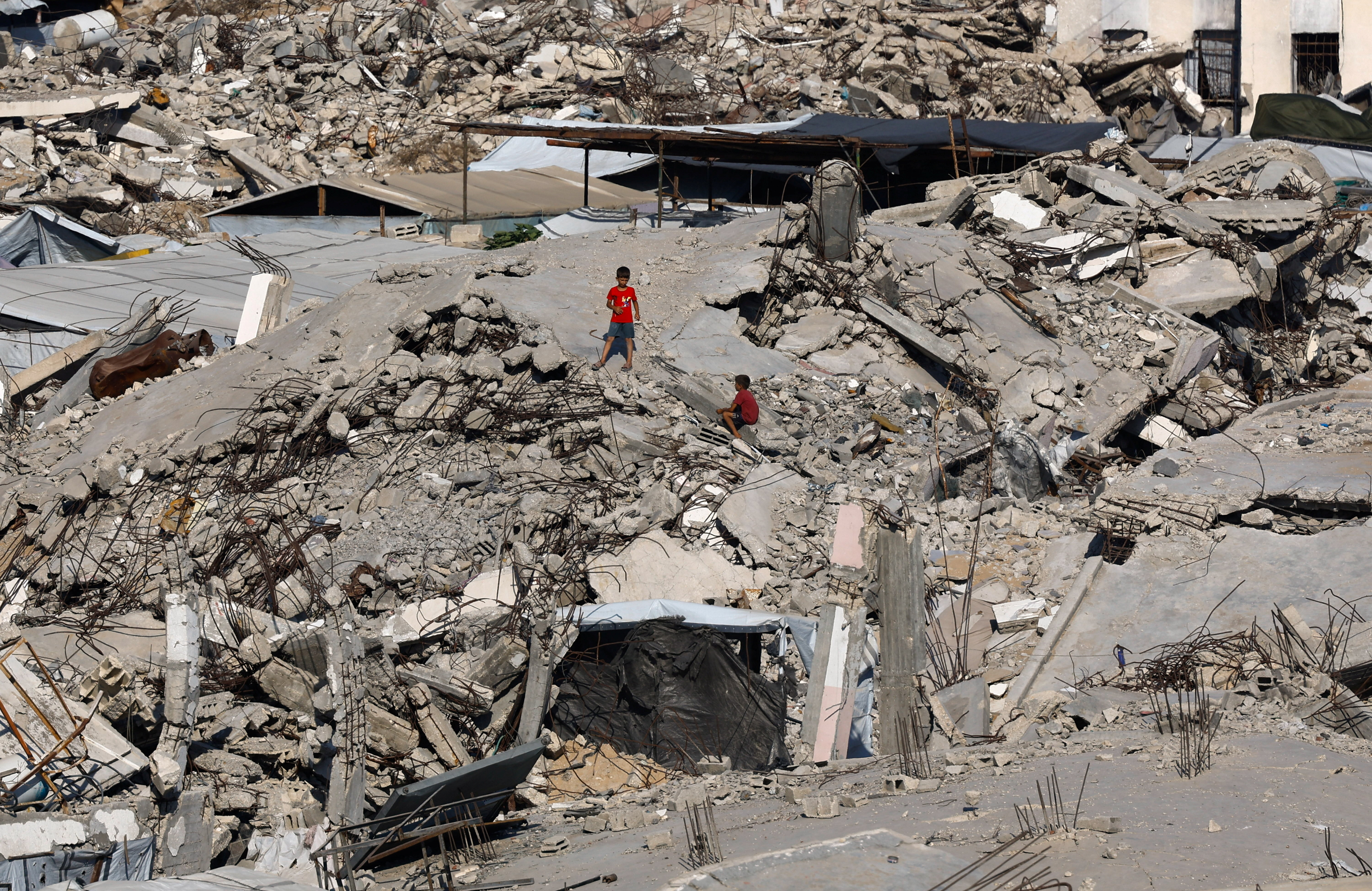 Young Palestinians amid the rubble of buildings destroyed during the war, at Jabalia refugee camp in the northern Gaza Strip, August 5, 2026.