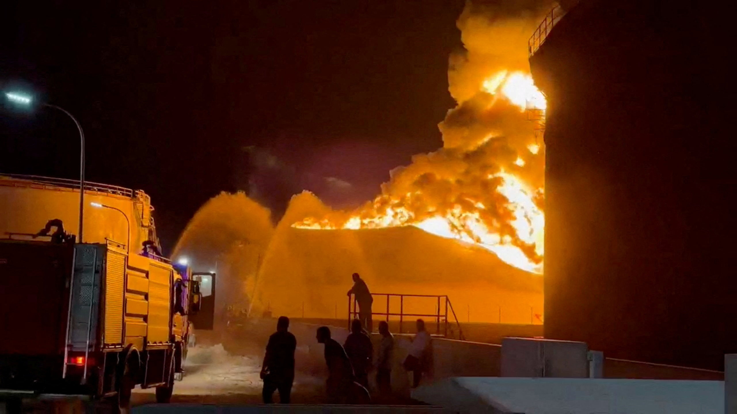 A fire in a storage tank burns as firefighters work to control the blaze, at an oil refinery in Zawiya, Libya August 10, 2026, in this still image from video obtained by Reuters.