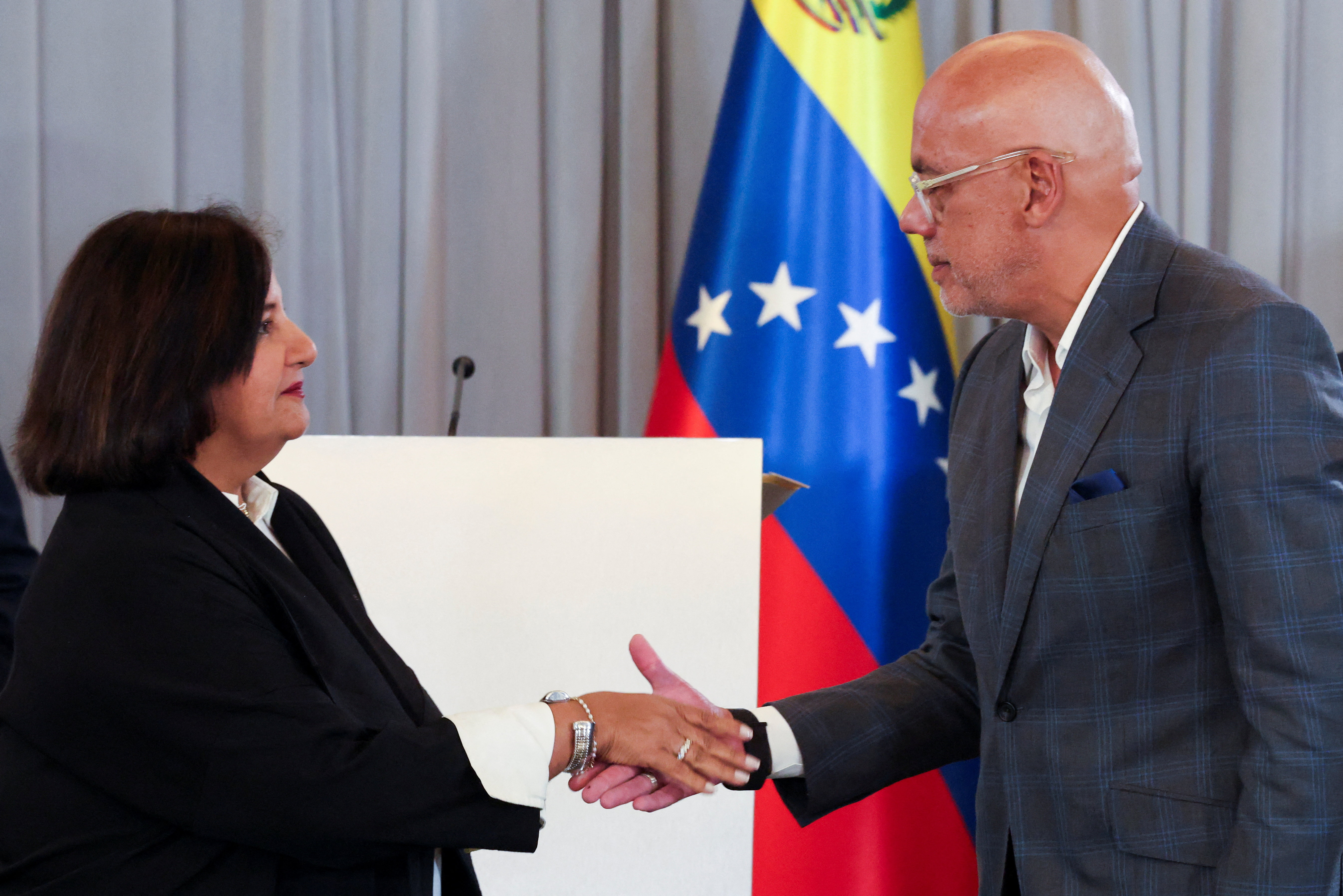 Venezuela's National Assembly President Jorge Rodriguez and former opposition lawmaker Dinorah Figuera shake hands during the closing day of the first cycle of national dialogue talks, in Caracas, Venezuela, August 12, 2026. REUTERS/Leonardo Fernandez Viloria