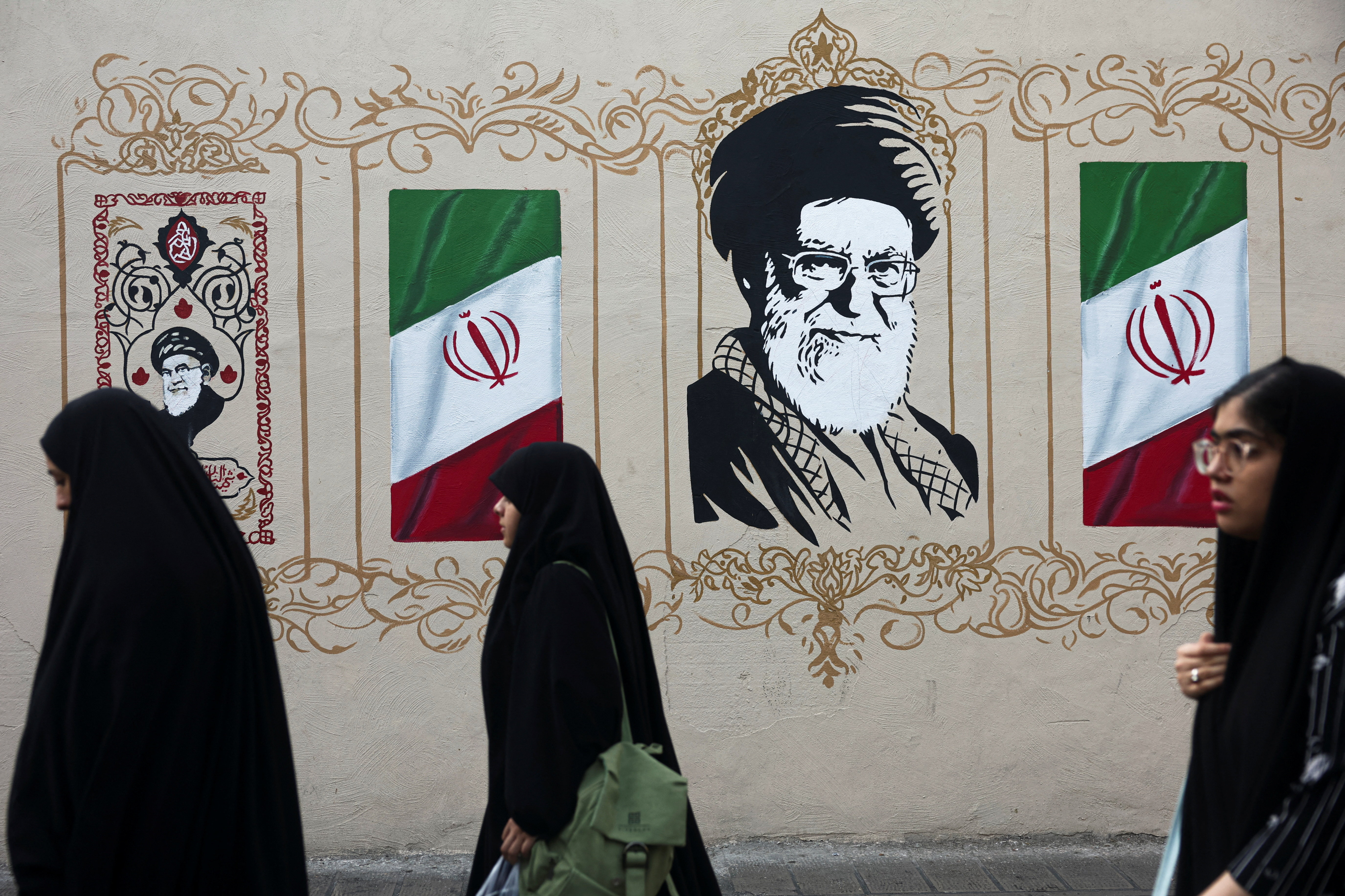 People walk by a mural depicting Iran's late Supreme Leader Ayatollah Ali Khamenei, on a street in Tehran, Iran, August 13, 2026. [Majid Asgaripour/WANA via Reuters]
