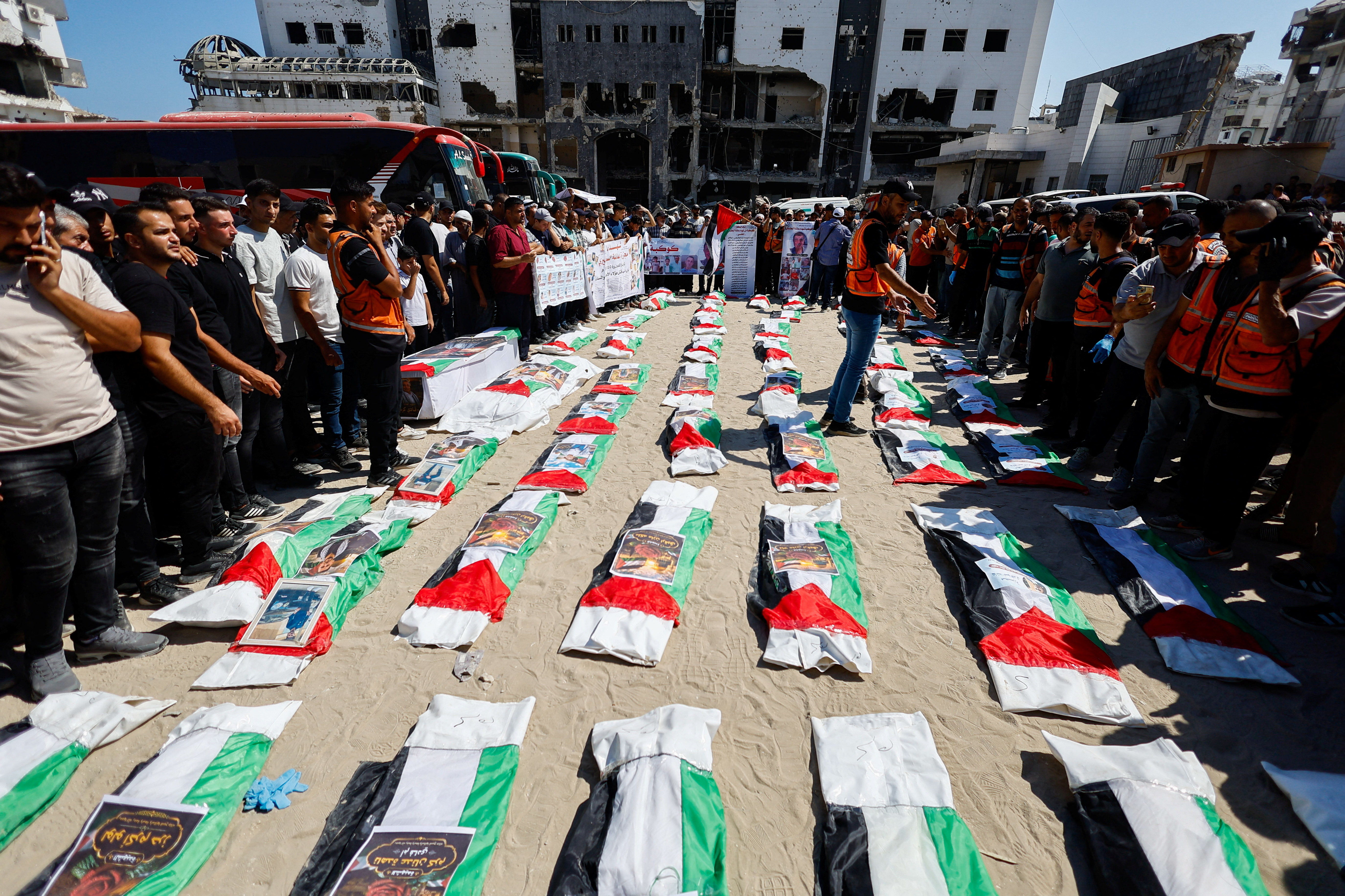 Palestinians attend the funeral of 50 people from three families killed during the war and whose bodies were retrieved from under the rubble recently, in Gaza City