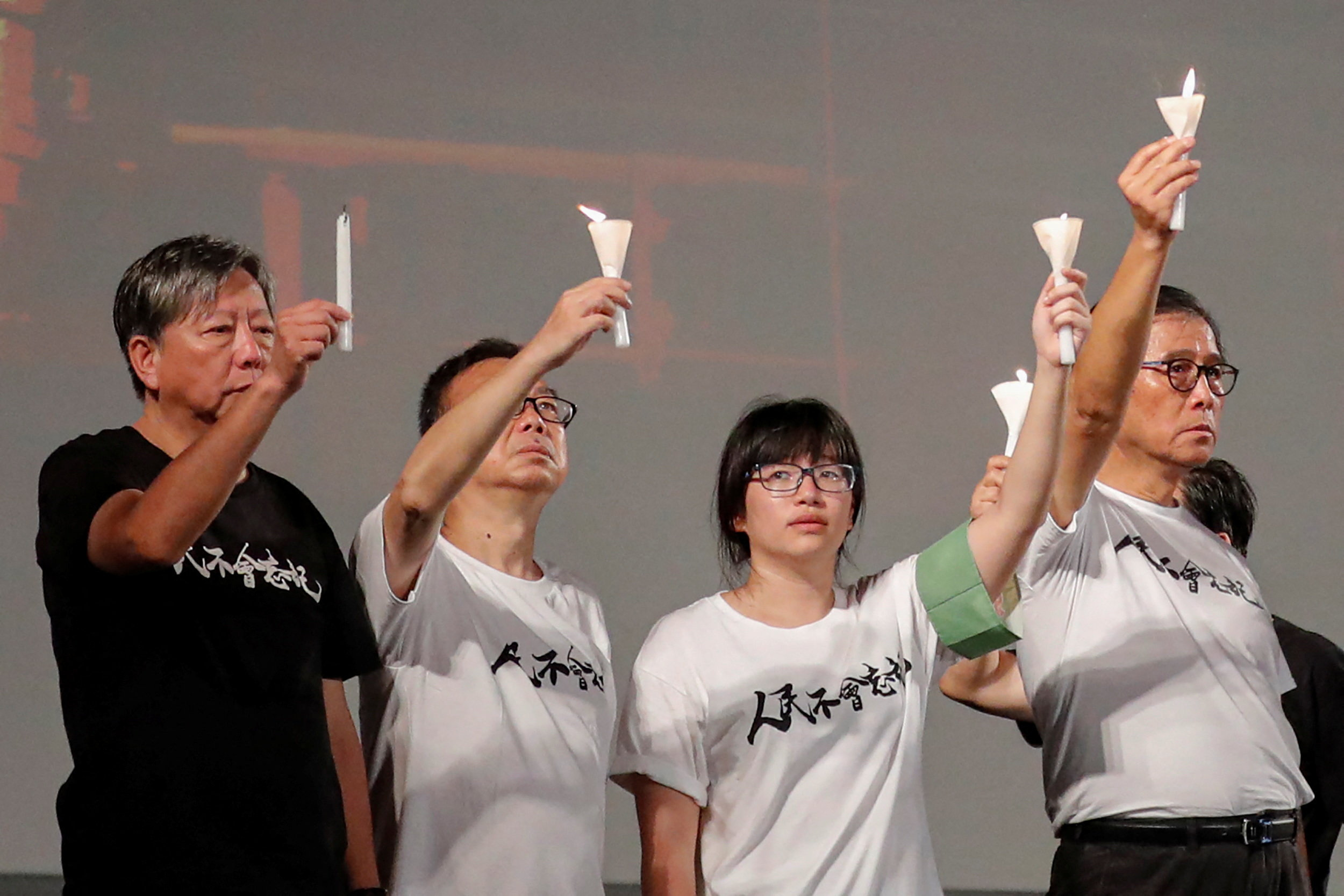 Pro-democracy activists Lee Cheuk-yan, left, Cheung Man-kwong and Chow Hang-tung, centre right, at a 2019 vigil for the victims of the Tiananmen Square massacre. [File: REUTERS/Tyrone Siu]
