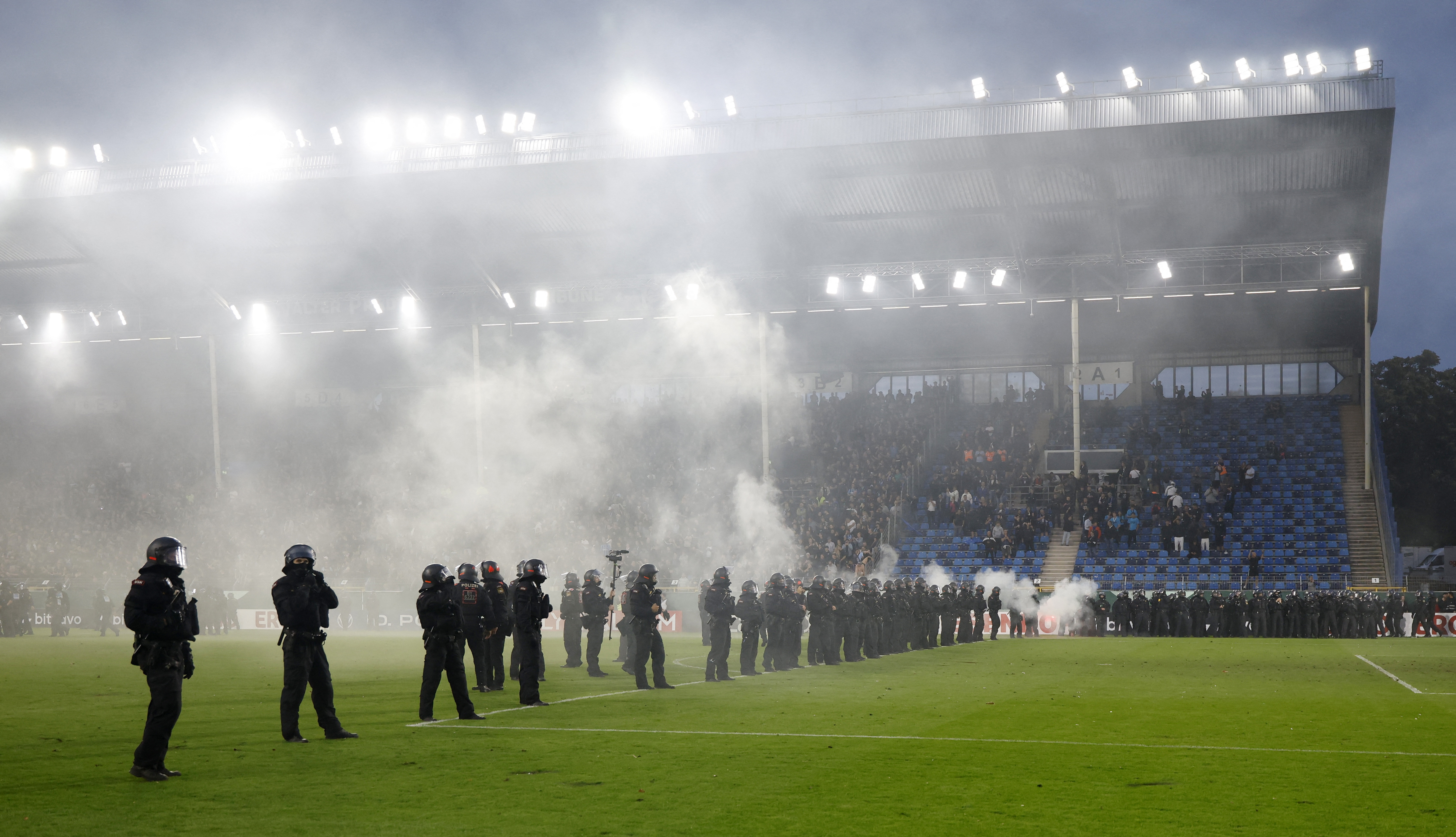 Police officers on the pitch as the match is paused due to fan trouble