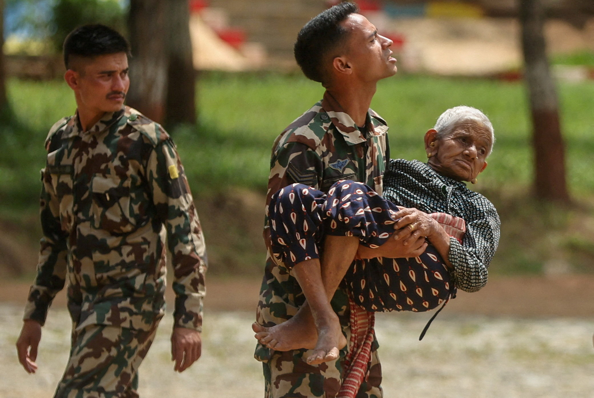 A soldier at a Nepali army training centre in Trishuli in Nuwakot district helps evacuate flood victims