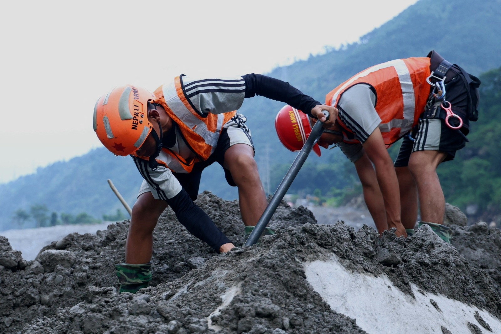 Rescue workers digging in mud