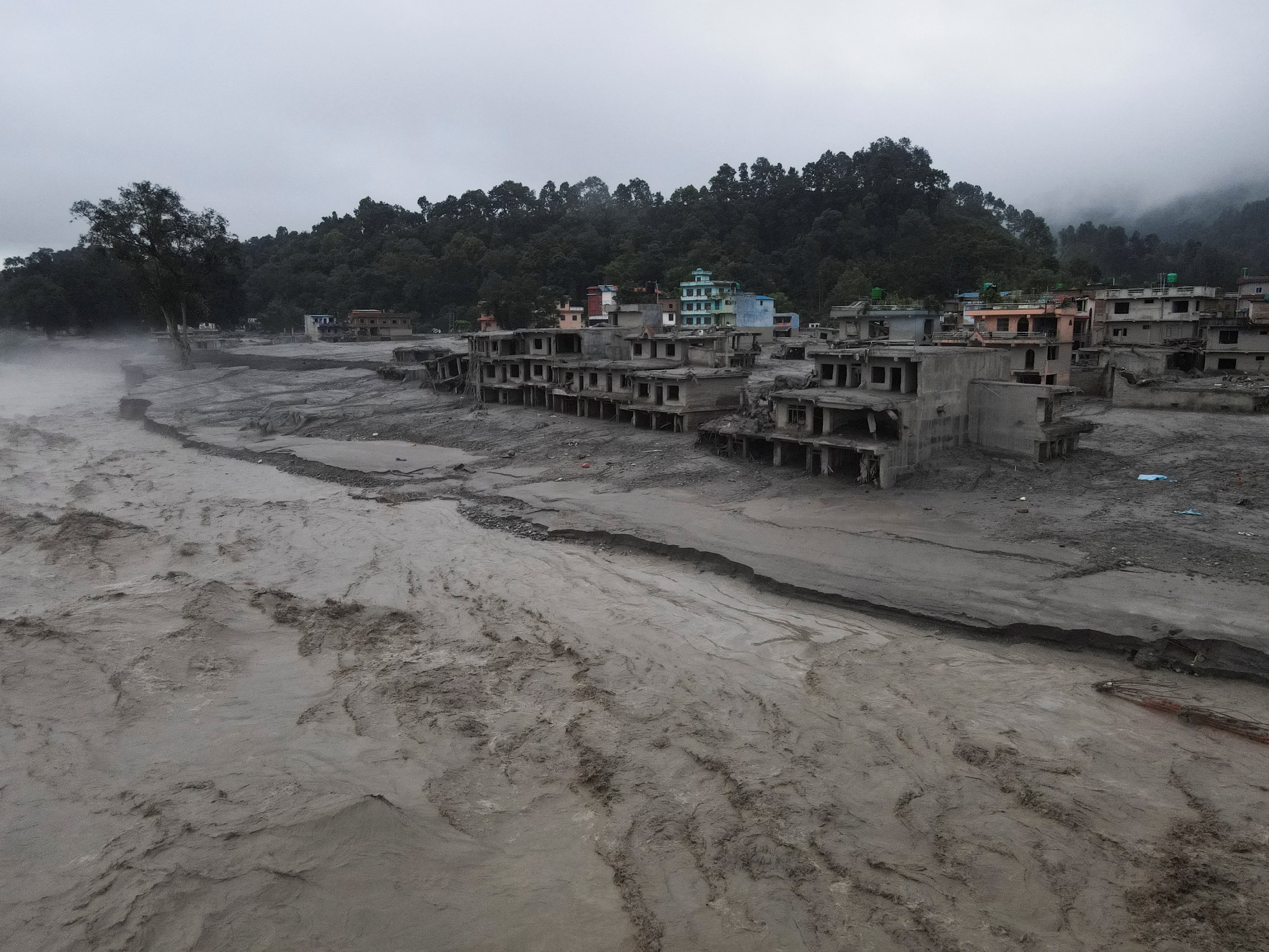 A drone view of the Trishuli river flowing past damaged buildings covered in mud after the deadly flash floods and mudslide, at Devighat, Nuwakot district, Nepal, August 31, 2026. REUTERS/Francis Mascarenhas