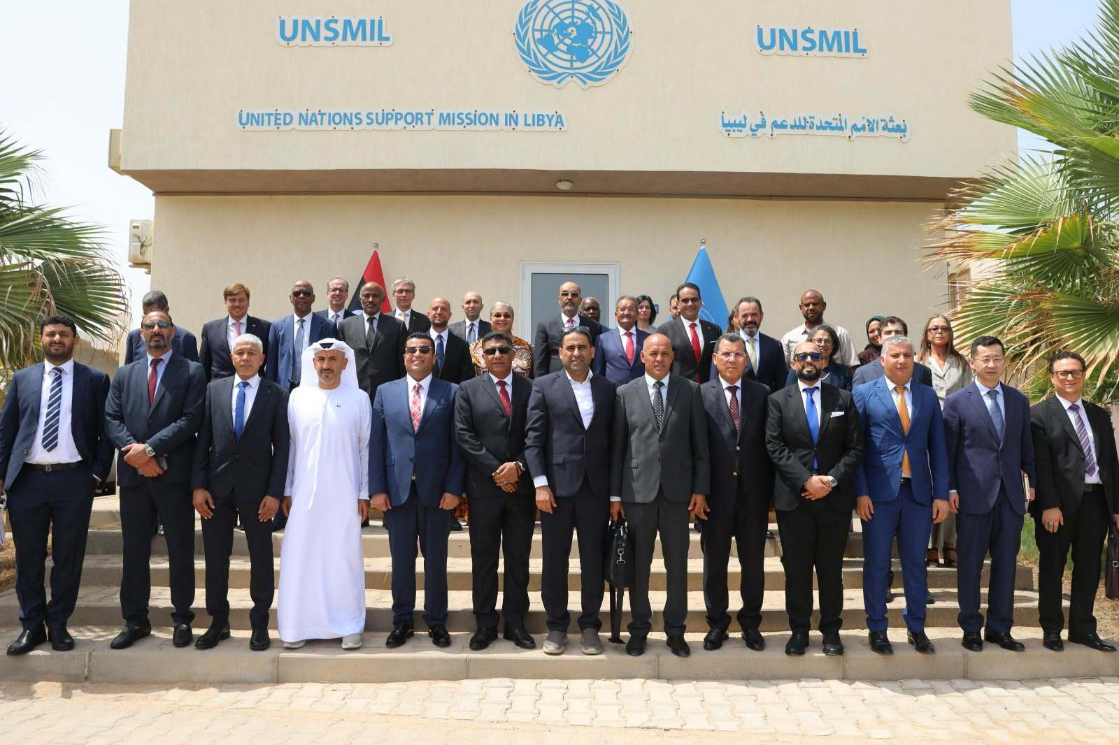 A group photo of officials outside a UNSMIL building.