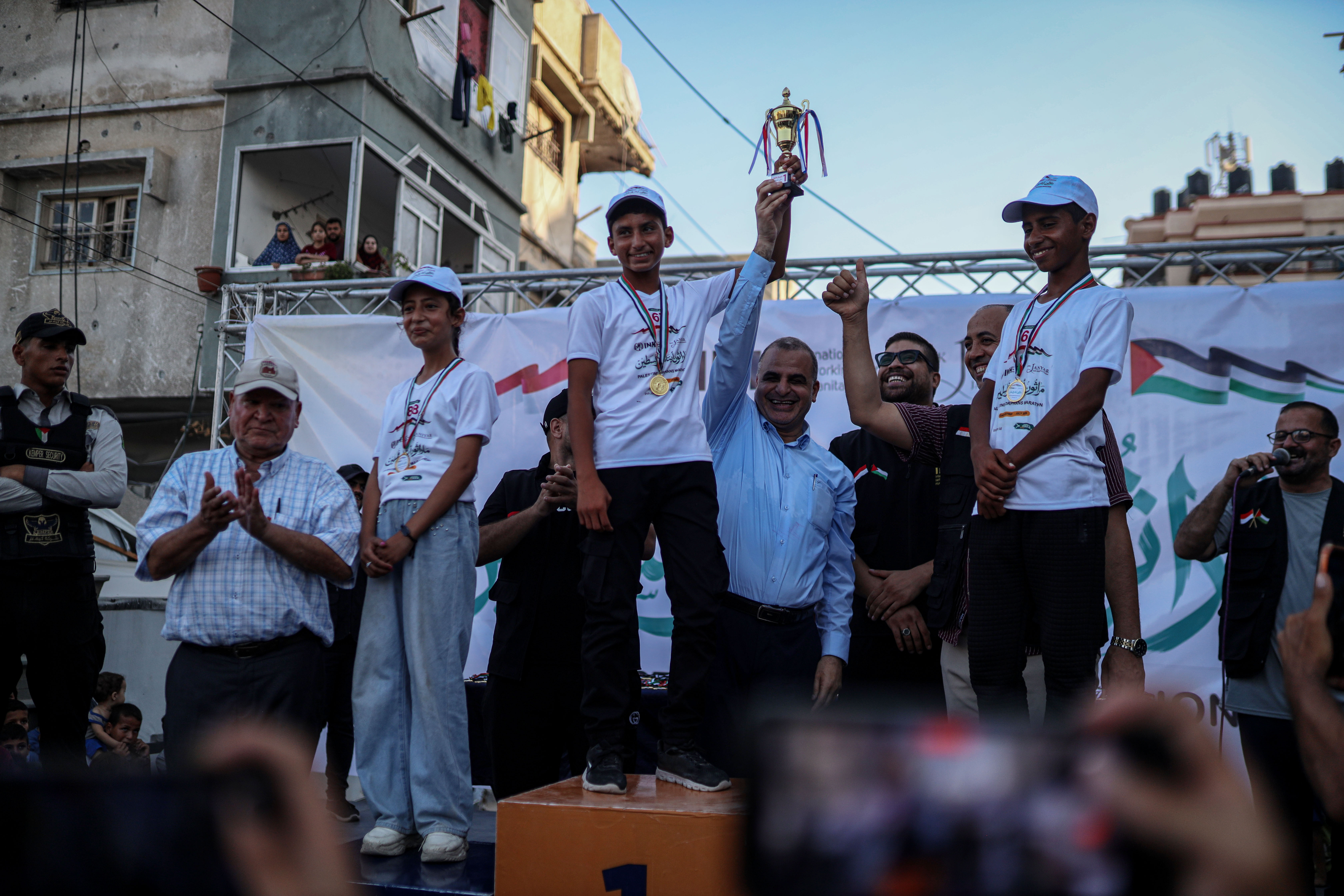 Organisers honour orphaned children who participated and won in the marathon[Abdelhakim Abu Riash/ Al Jazeera] 
