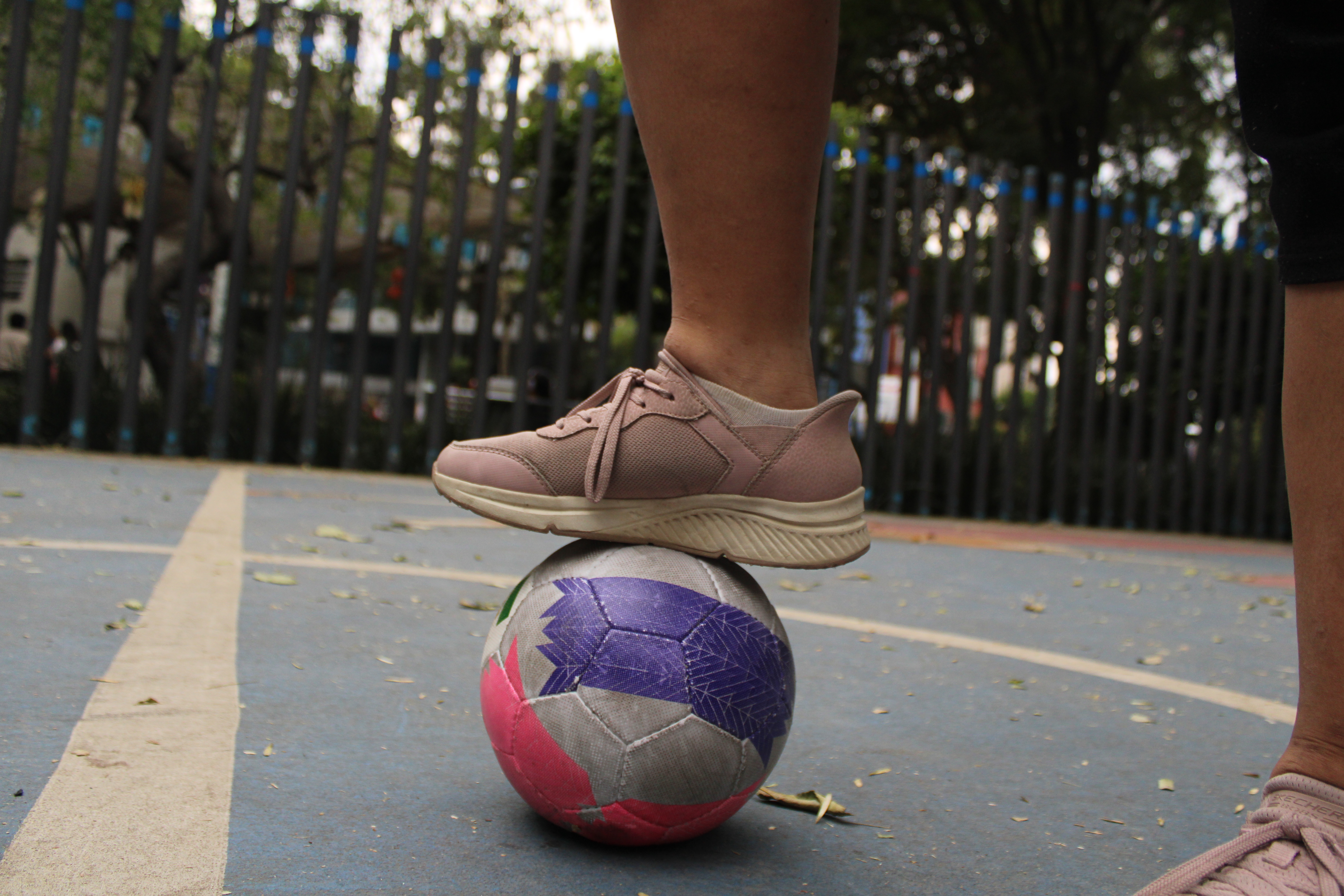 A specialized ball used in blind soccer rests on the concrete of a multi-use sports court in Mexico City. Unlike a conventional soccer ball, the ball contains internal rattles that allow players to track its movement through sound, helping