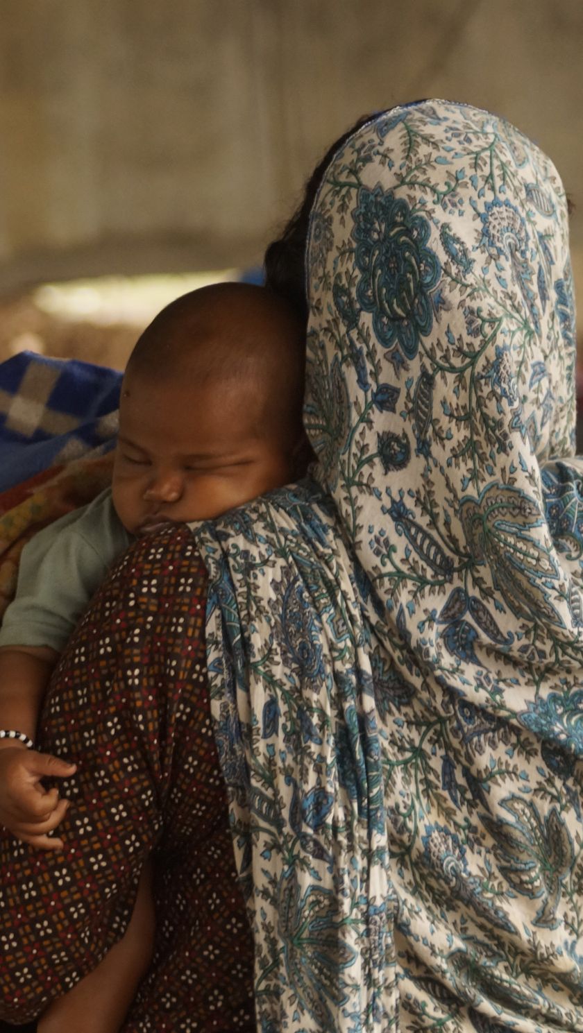A woman holds a sleeping baby during the Chita Andolan protest near Kupi village in Madhya Pradesh