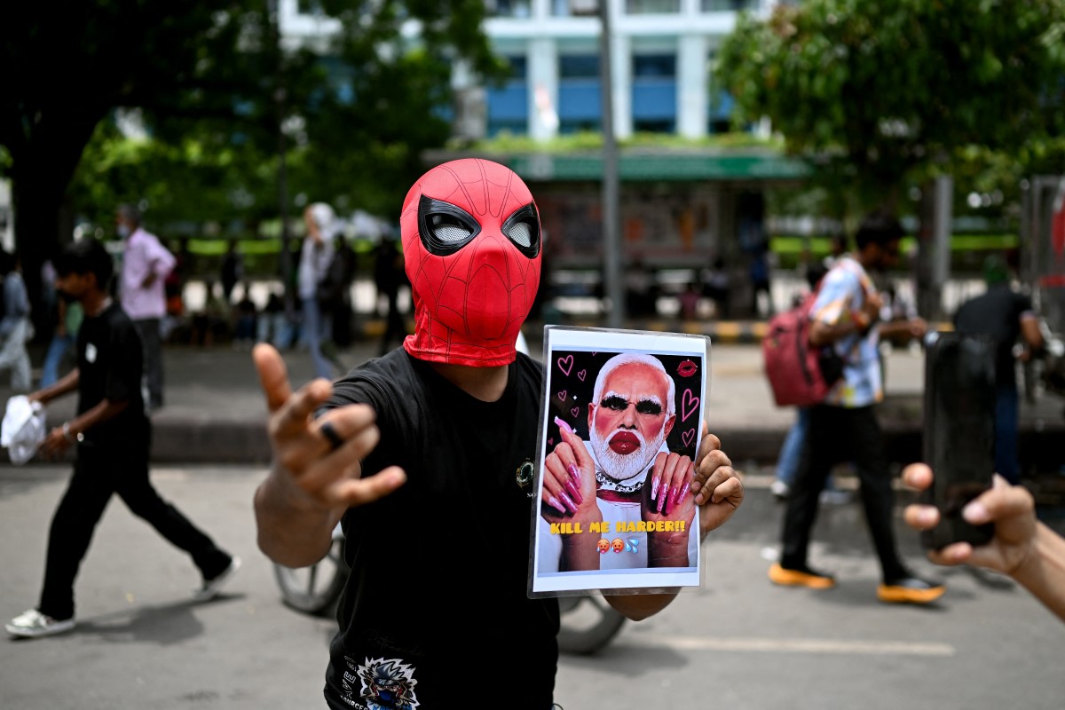 A Cockroach Janta Party (CJP) supporter holds a placard of India’s Prime Minister Narendra Modi at Jantar Mantar in New Delhi on July 25, 2026, during the ongoing protest to demand the resignation of India’s Education Minister Dharmendra Pradhan over alleged NEET exam irregularities
