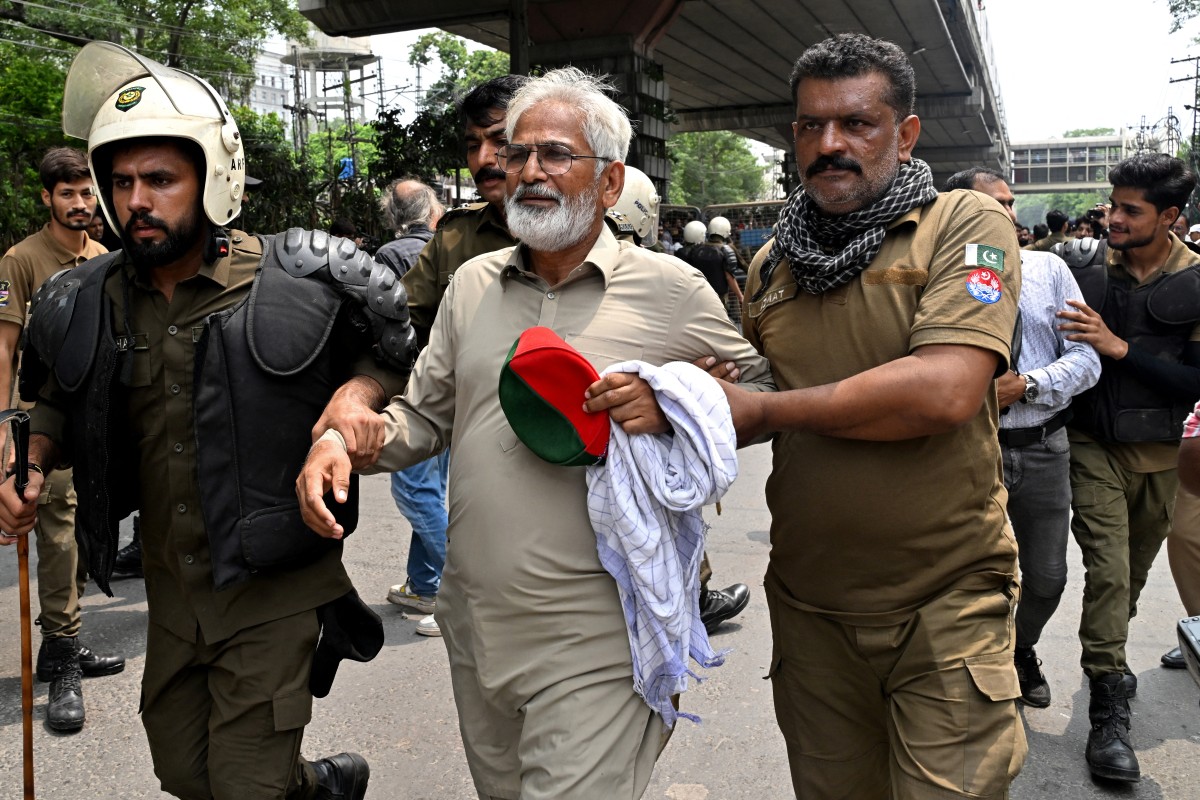 Police personnel detain a supporter of Pakistan Tehreek-e-Insaf (PTI) party during a protest demanding the release of their jailed leader and the country's former Prime Minister Imran Khan, in Lahore