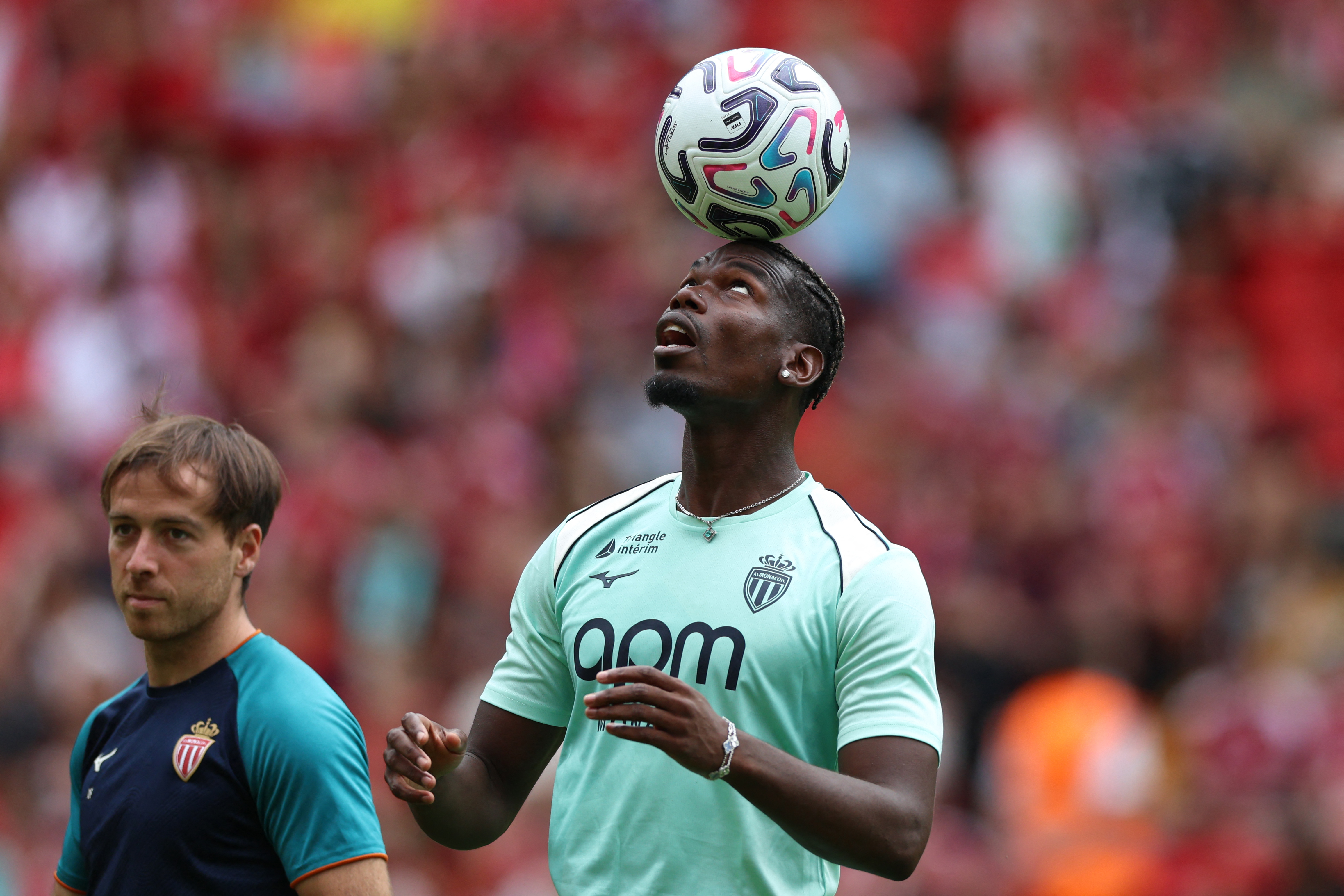 A football player balances the ball on his head