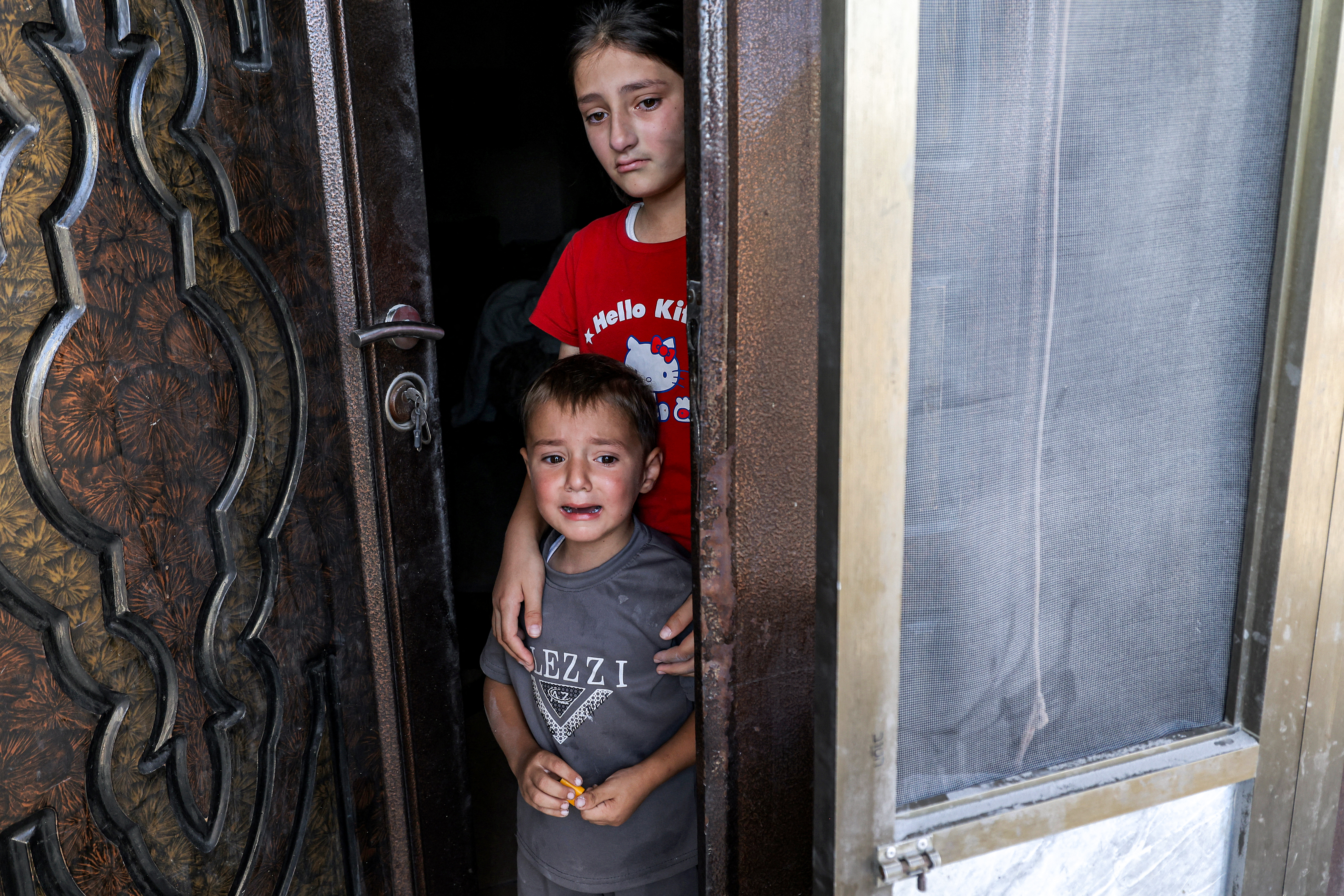 Child relatives of Palestinian Farouk Ramadan, who was involved and killed in clashes with Israeli settlers on July 24, killing two, react after his home in the upper story was subject to a controlled-demolition in the Palestinian village of Tell in the occupied West Bank on August 11, 2026. Israel, whose army has occupied the West Bank since 1967, regularly demolishes the homes of Palestinians accused of carrying out deadly attacks against Israelis. The government defends the deterrent effect of these demolitions, but critics denounce the practice as a form of collective punishment that leaves families homeless. (Photo by JAAFAR ASHTIYEH / AFP)