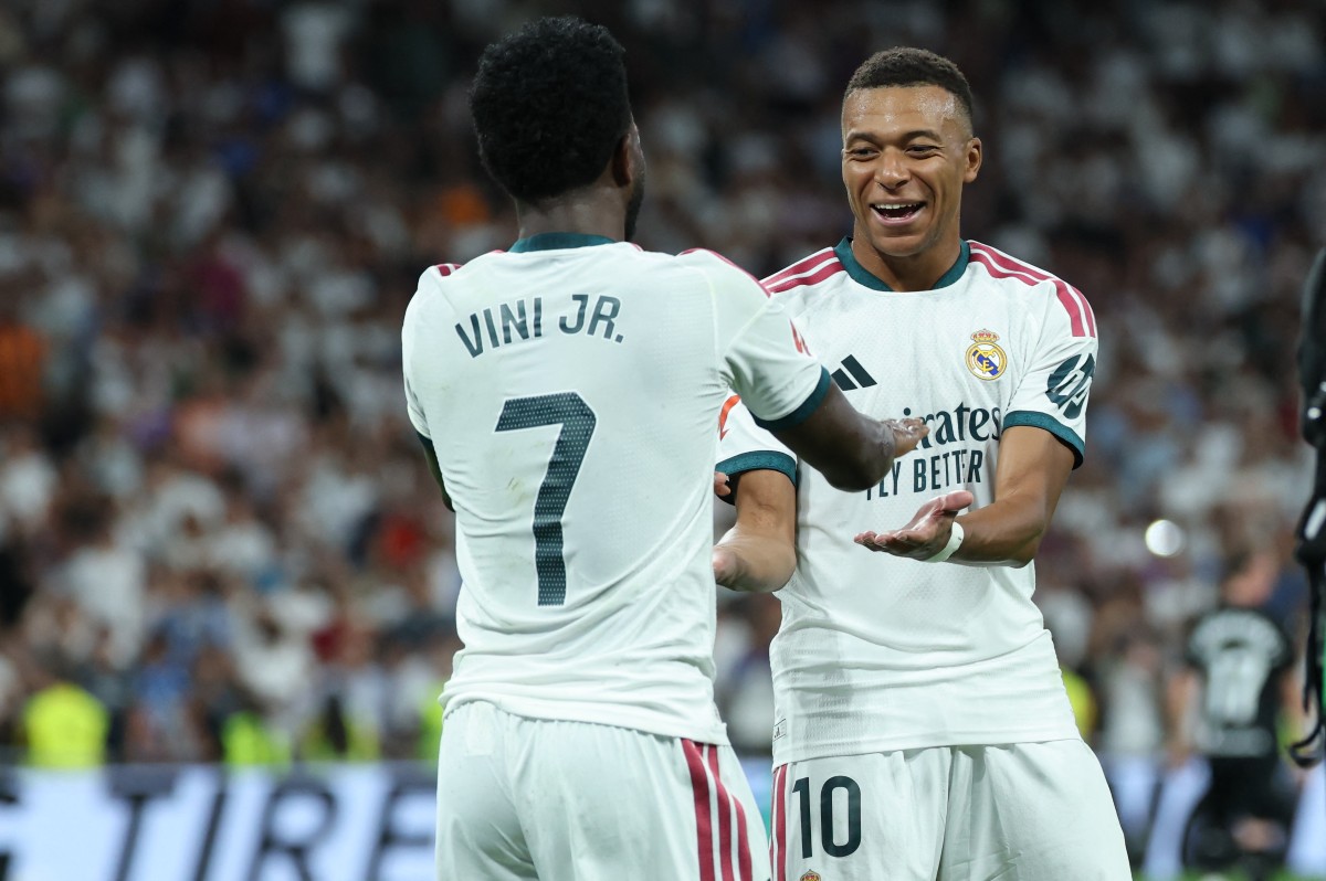 Real Madrid's Brazilian forward #07 Vinicius Junior (L) celebrates scoring his team's third goal with Real Madrid's French forward #10 Kylian Mbappe during the Spanish league football match between Real Madrid CF and Real Sociedad at Santiago Bernabeu Stadium in Madrid on August 26, 2026. (Photo by Thomas COEX / AFP)