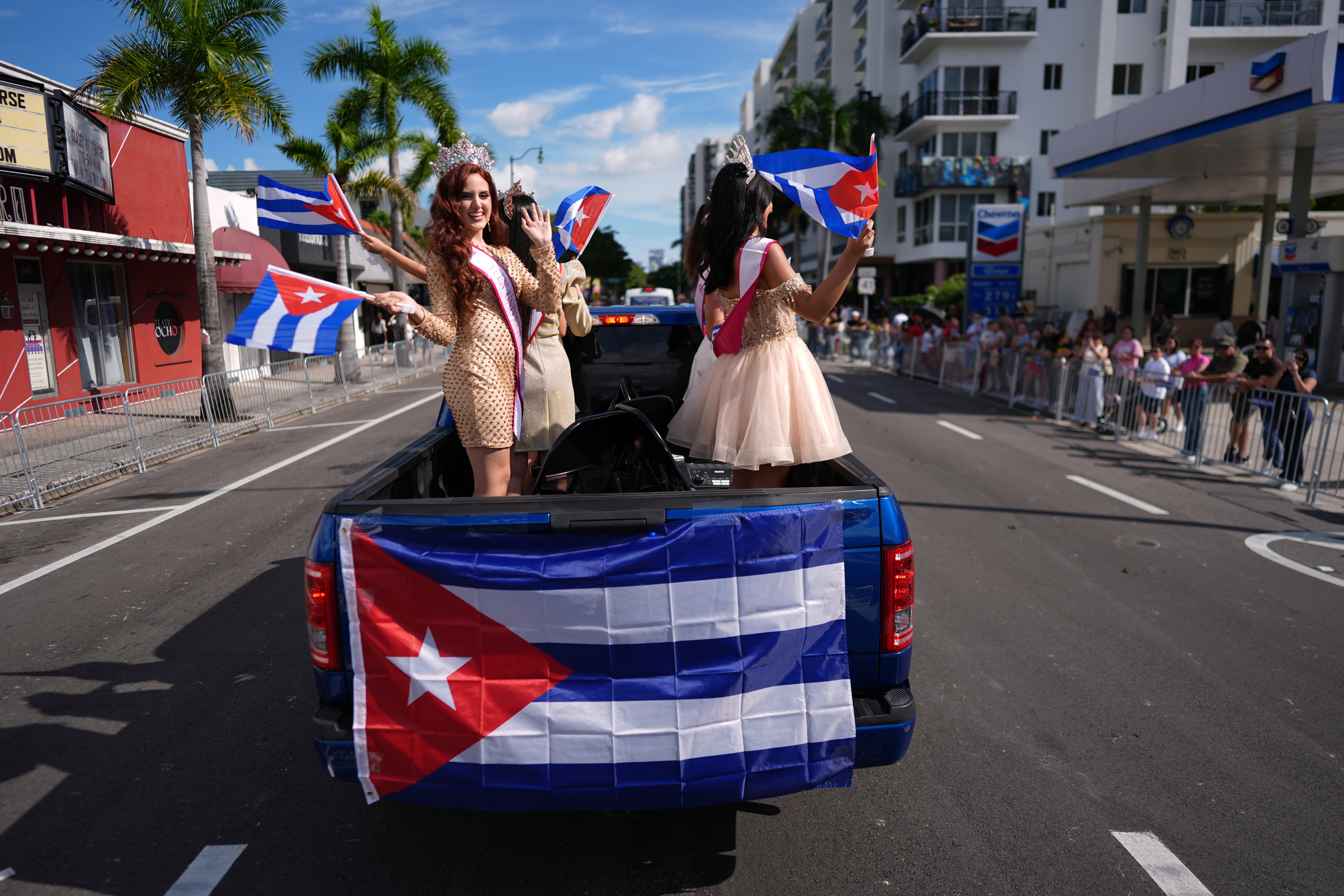 Young women wearing pageant sashes wave Cuban flags as they ride in a weekend parade celebrating January 6th's Three Kings Day, also known as feast of the Epiphany, in Miami's Little Havana neighborhood, Sunday, Jan. 11, 2026. (AP Photo/Rebecca Blackwell)