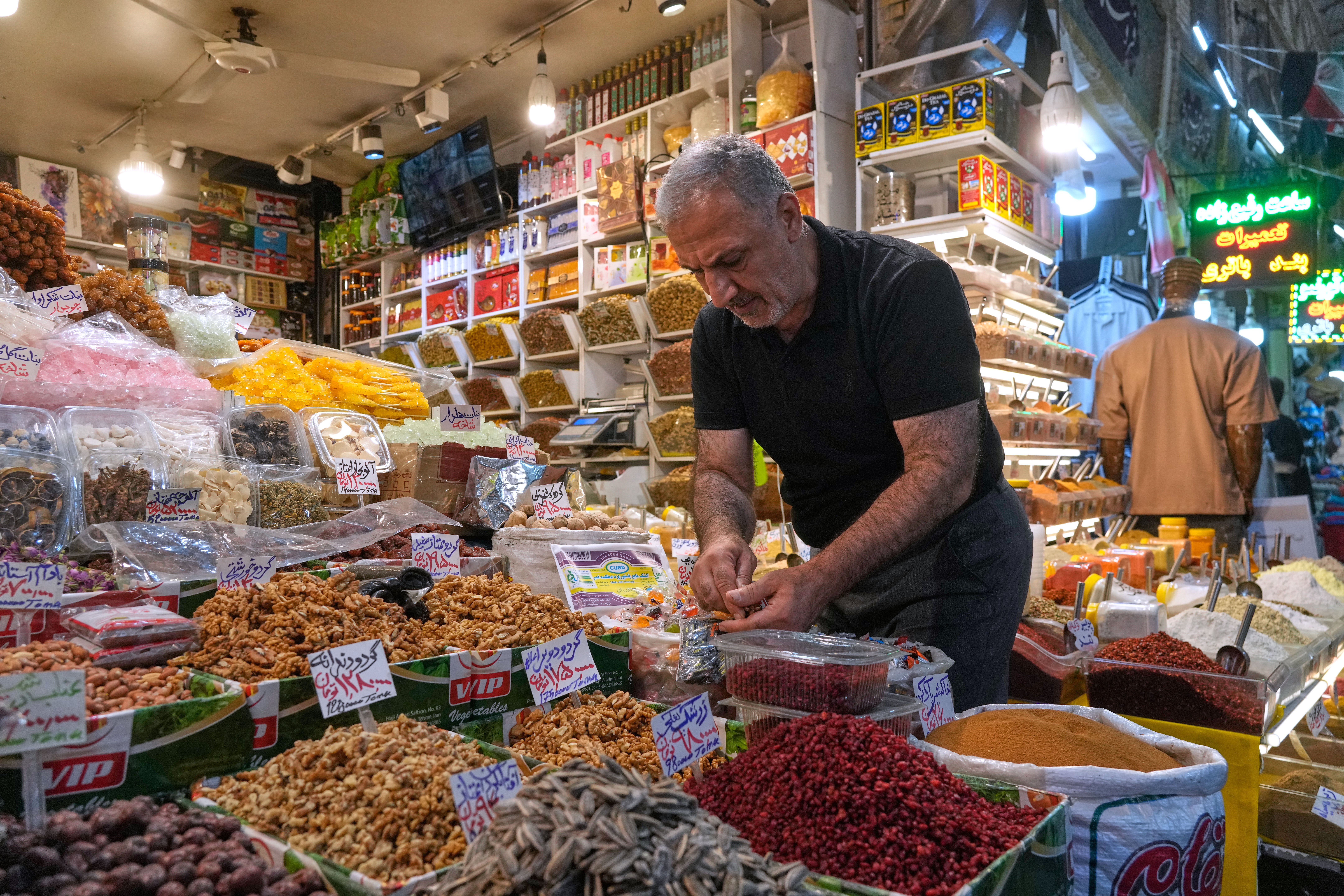 A shopkeeper arranges nuts at his shop at the Tajrish bazaar in northern Tehran