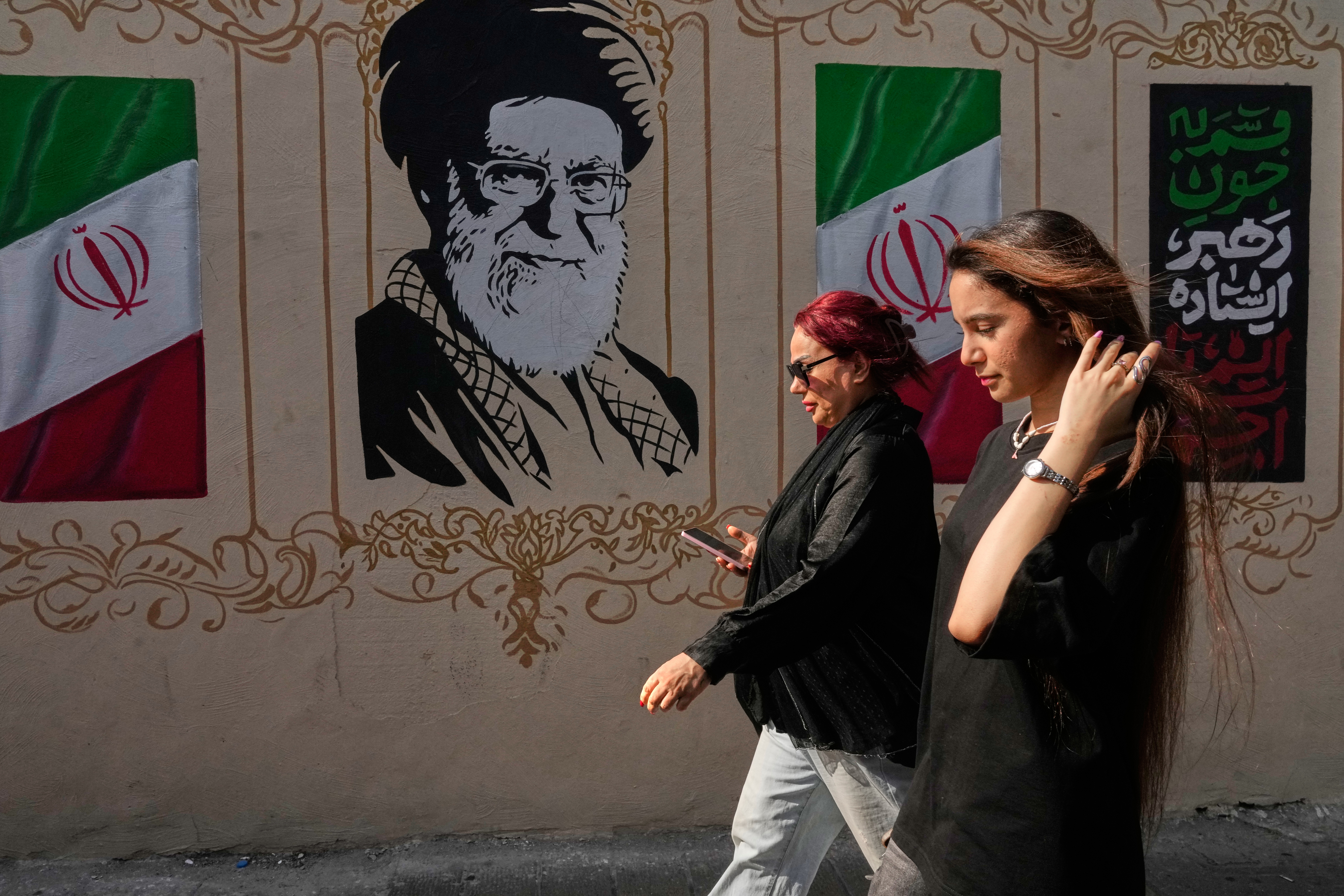 Women walk past a portrait of the late Iranian Supreme Leader Ayatollah Ali Khamenei in downtown Tehran, Iran, August 20, 2026. [Vahid Salemi/AP Photo]