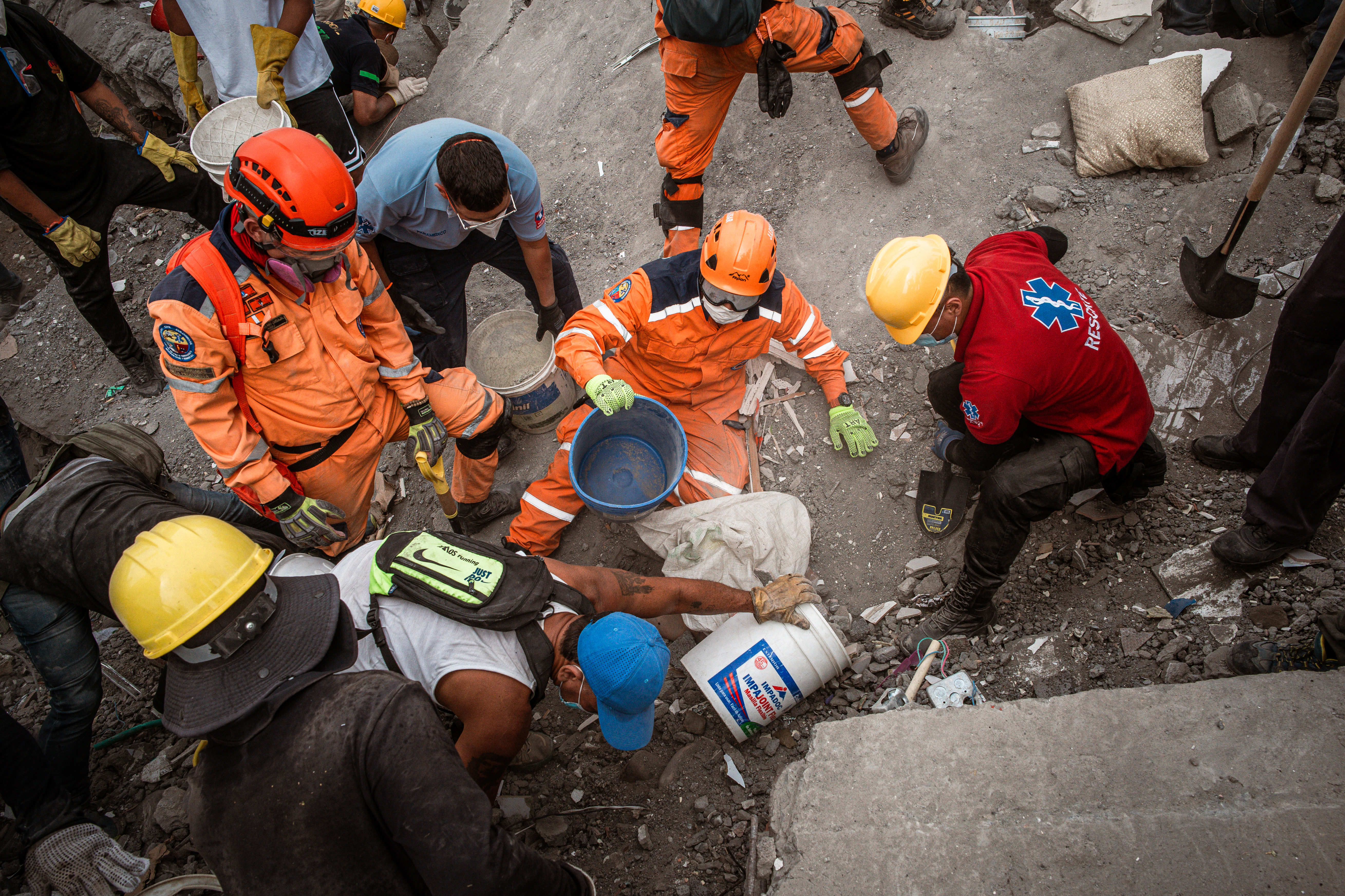 Rescuers attempt to locate survivors beneath the rubble of a collapsed apartment block close to Refugio Park, Cali. [Euan Wallace / Al Jazeera]