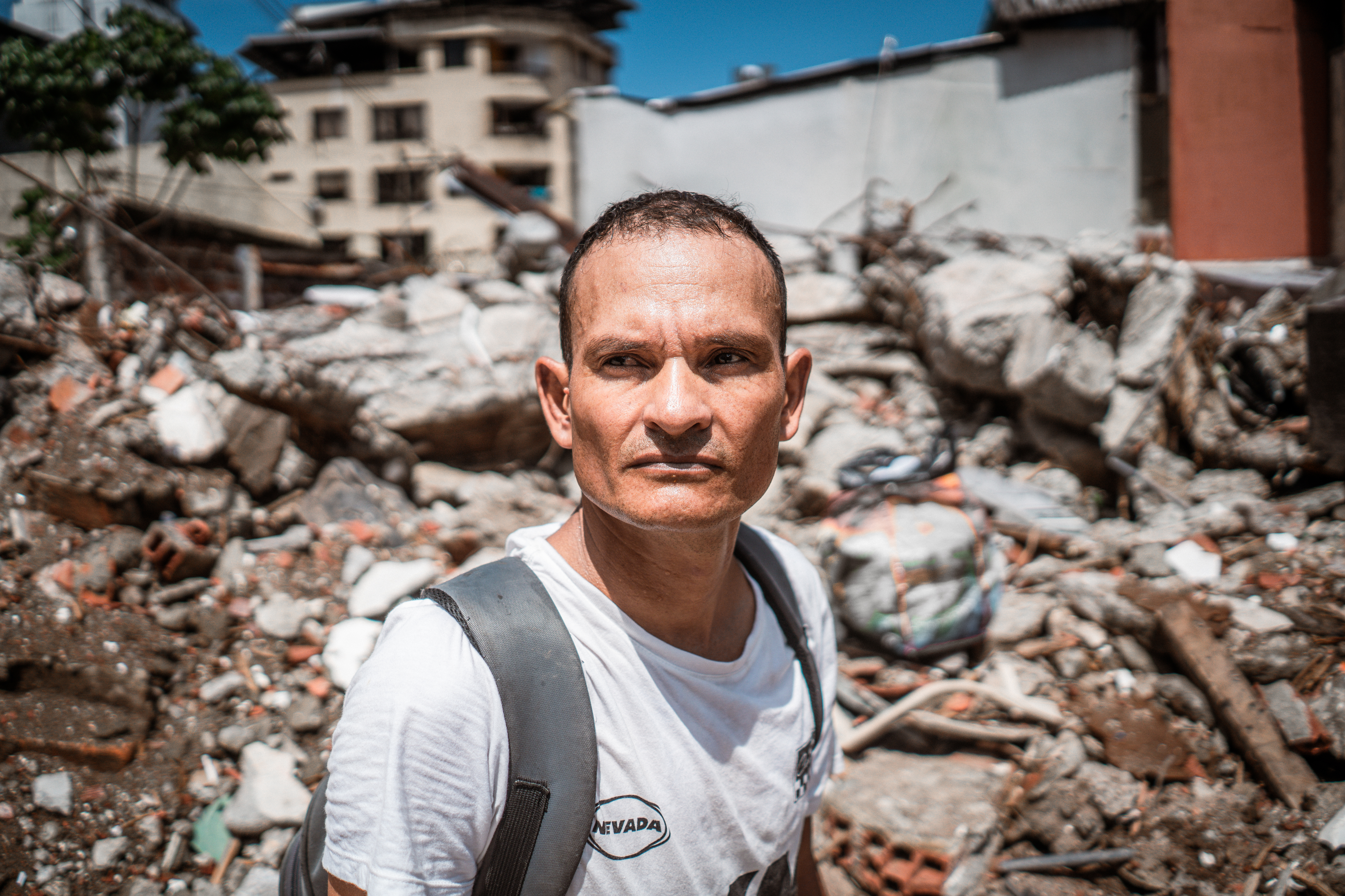 Jorge Martinez, a parking attendant, keeps watch at the site of a collapsed building near the center of Buenaventura. He says that he has witnessed looting at the site, and calls for heightened police presence in the area. [Euan Wallace / Al Jazeera]