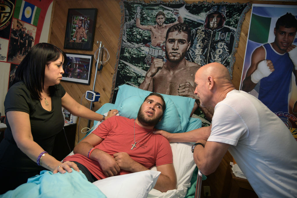 Nieves Melendez, left, and Richard Colon tend to their son, former professional boxer Prichard Colon, while he lies in a vegetative state in his bedroom at his family home in Winter Park, Fla., Monday, May 22, 2017. Prichard Colon suffered a traumatic brain injury during his bout against Terrel Williams.