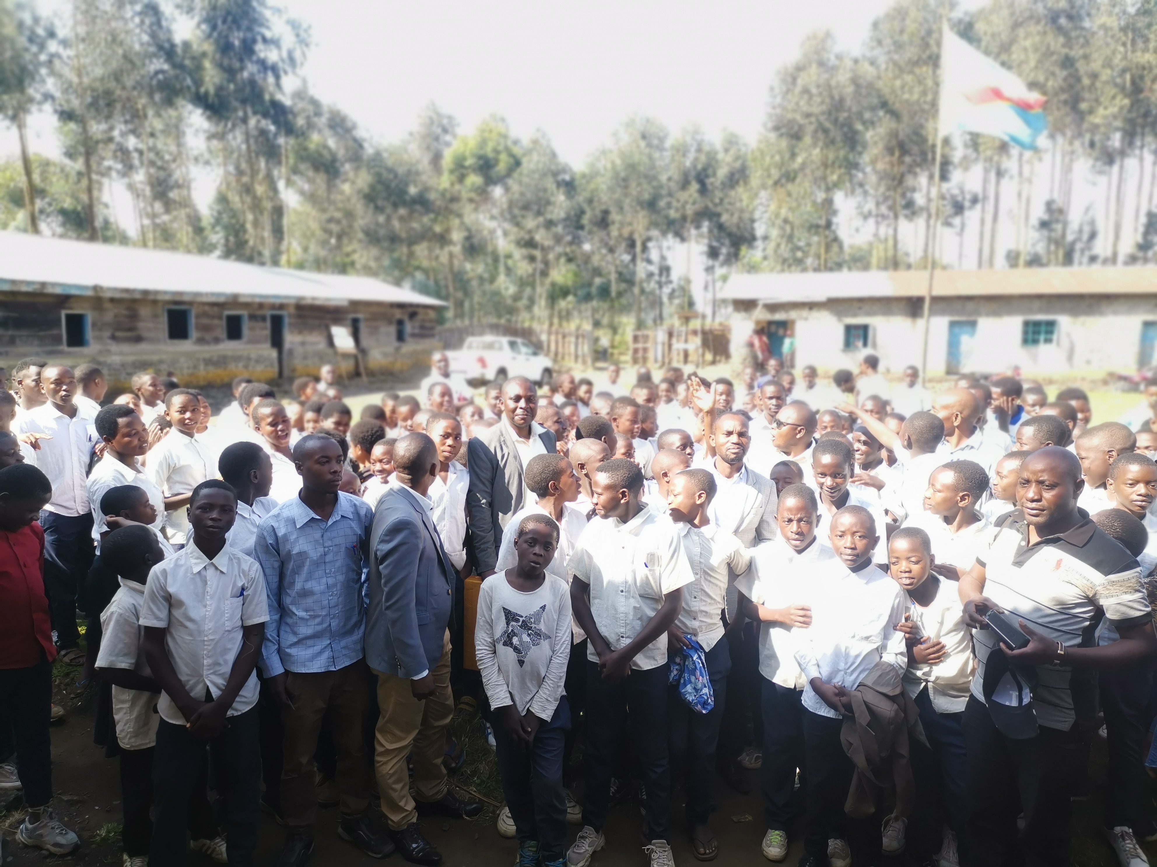 Students gather in a school courtyard with school officials as the new academic year begins in the Democratic Republic of the Congo.