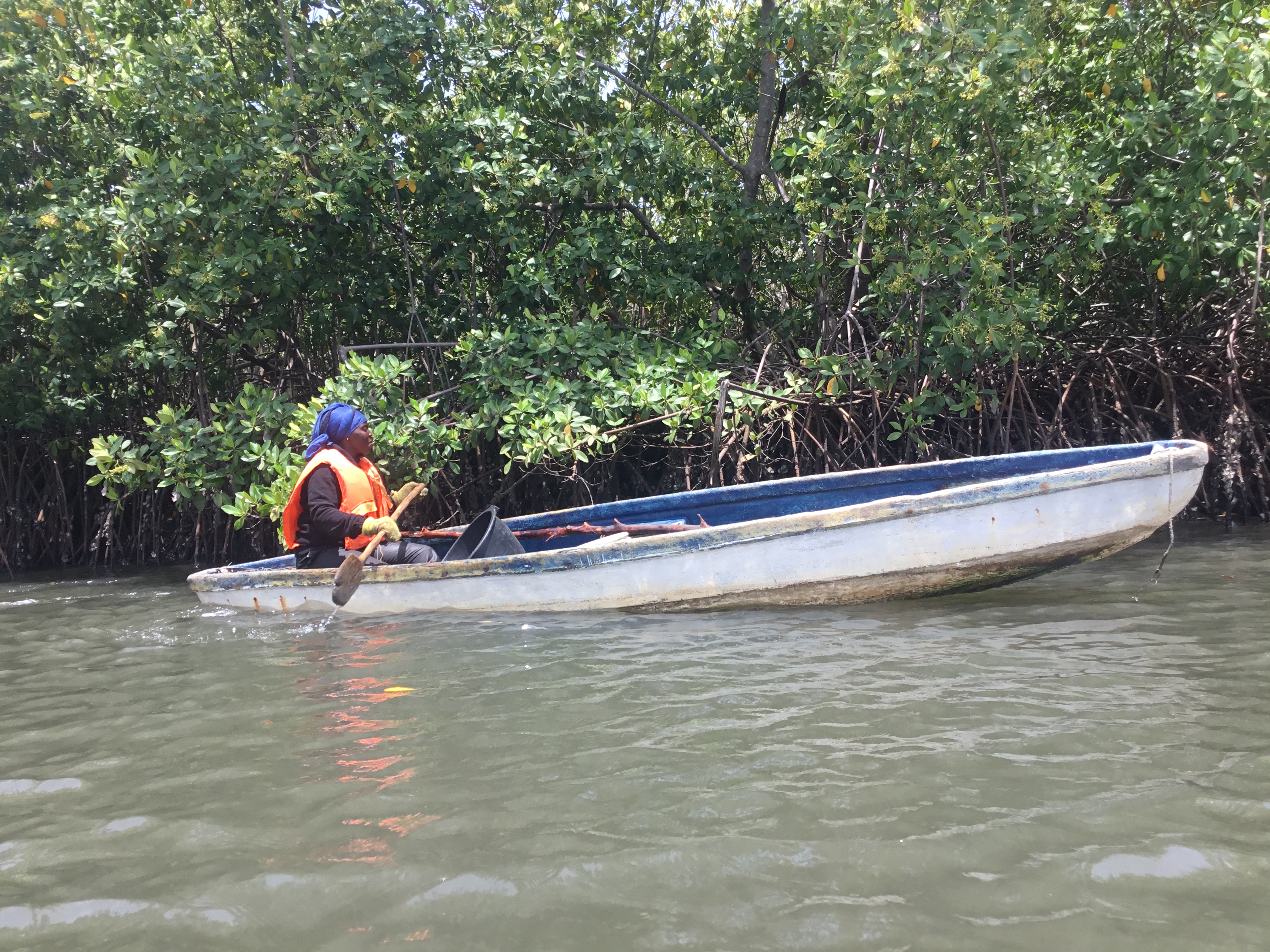 Fatou pushes her canoe into the water, beginning another day of searching for crabs in the mangrove wetlands that sustain her livelihood