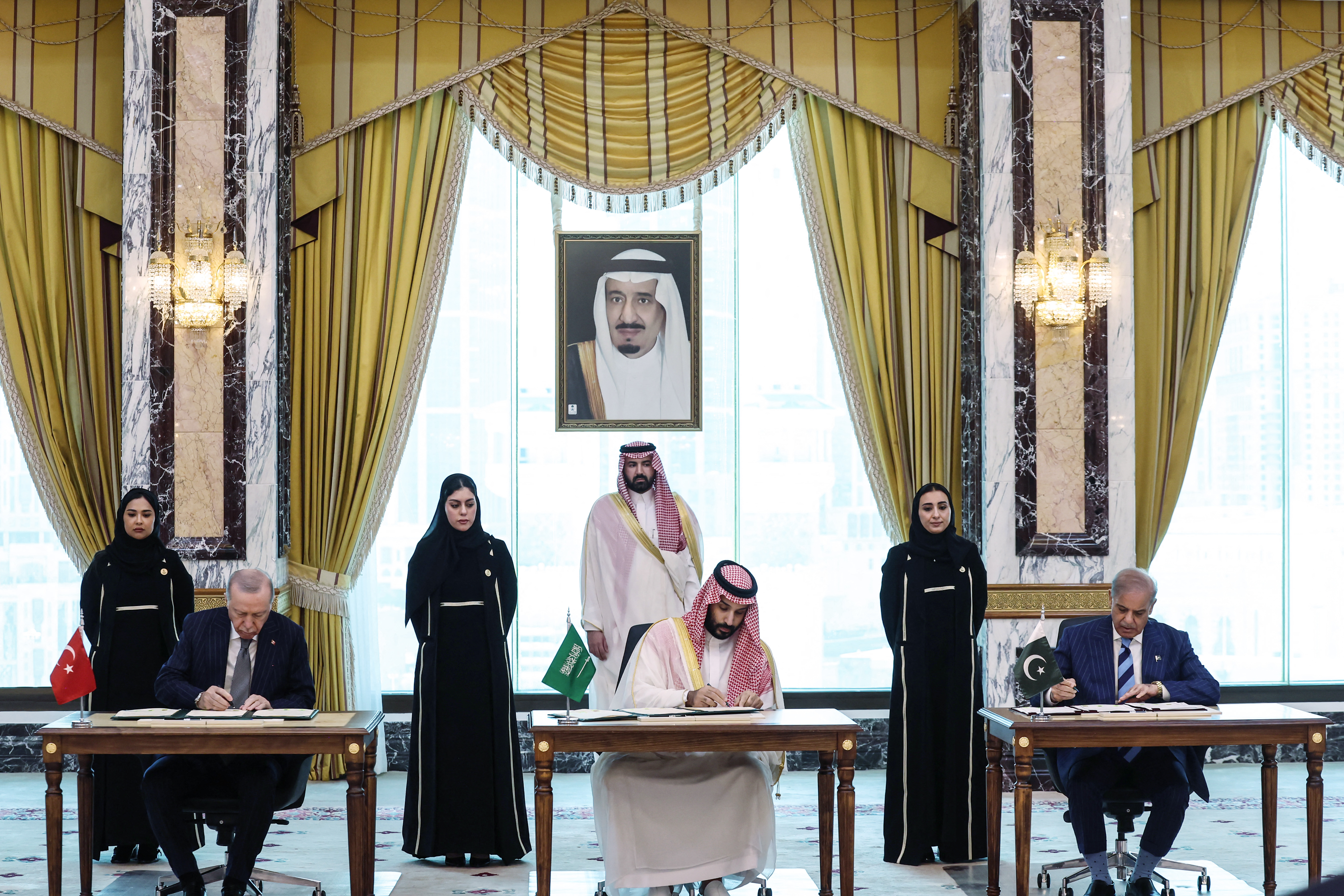 This handout photograph taken and released by the Turkish Presidency press office on August 7, 2026, shows Saudi Arabia's Crown Prince Mohammed bin Salman, flanked by Turkey's President Recep Tayyip Erdogan (L) and Pakistan’s Prime Minister Shehbaz Sharif, signing a joint defence agreement in Mecca.