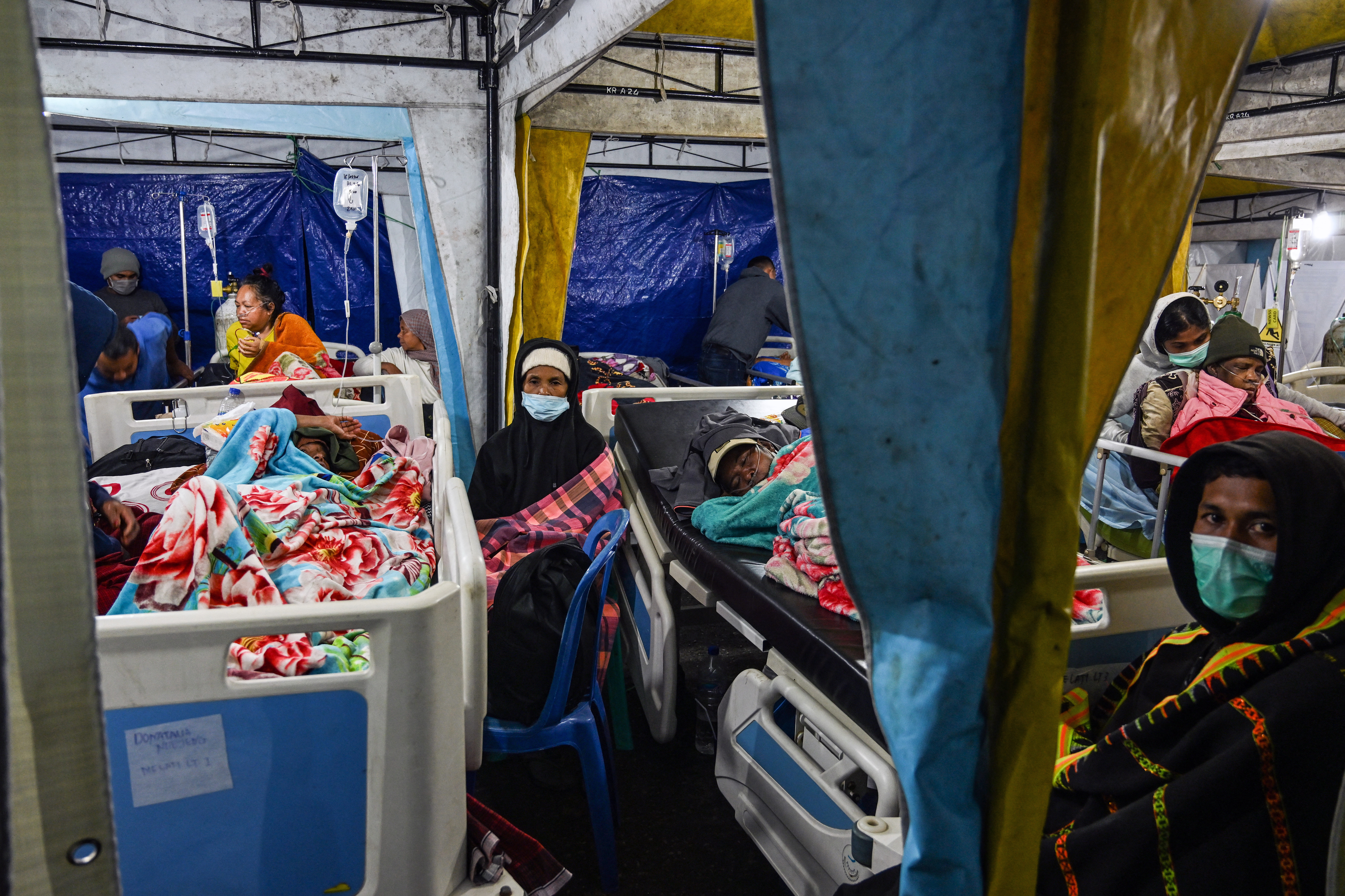 TOPSHOT - Earthquake victims are treated in a temporary medical tent due to fears of aftershocks, in front of the Ruteng hospital in Ruteng, Manggarai, East Nusa Tenggara on August 15, 2026.