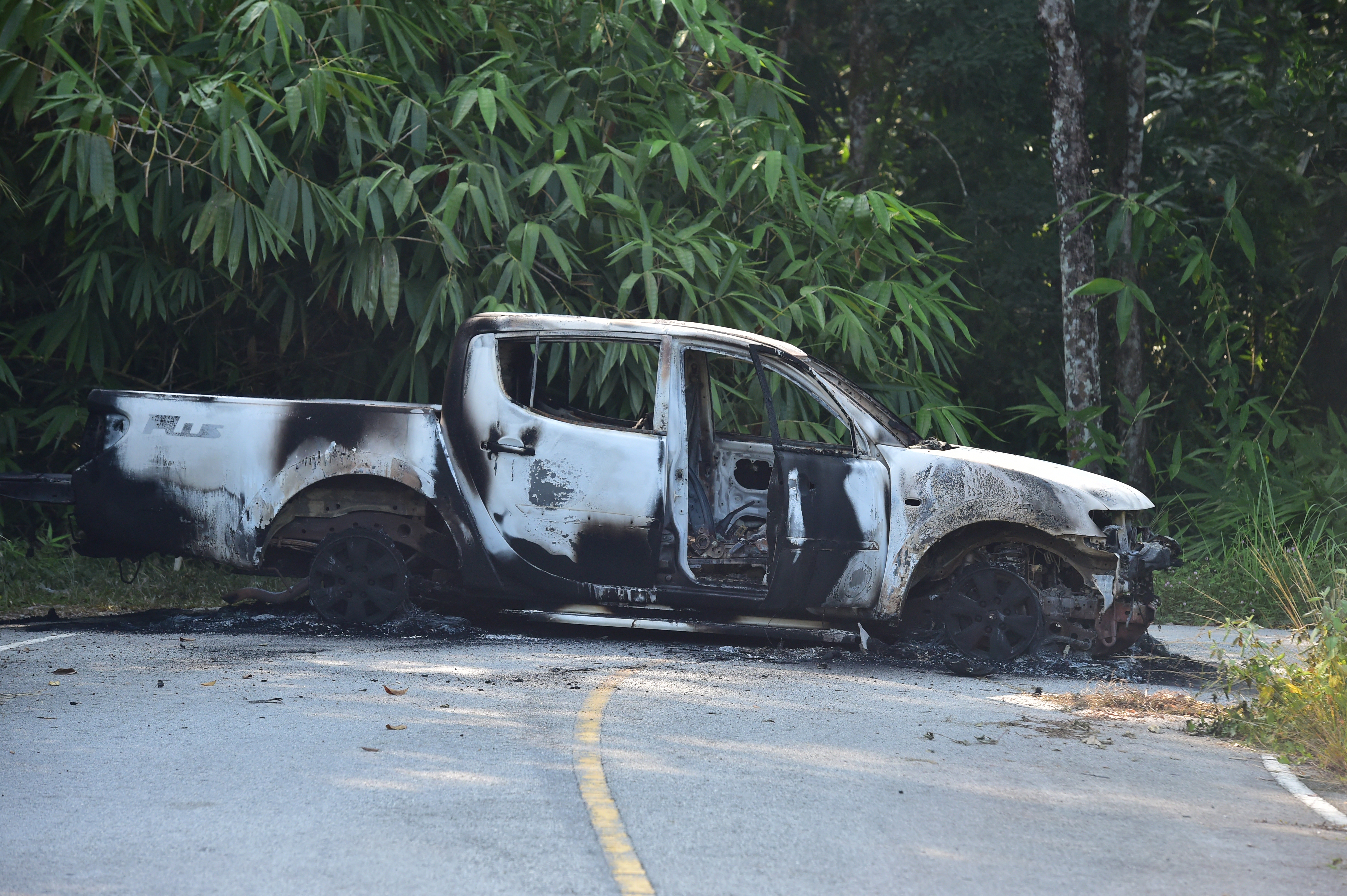 A charred vehicle is seen on a road in Ra-ngae district in the southern Thai province of Narathiwat on August 23, 2026, following dozens of coordinated arson and incendiary attacks across Thailand's insurgency-hit south.