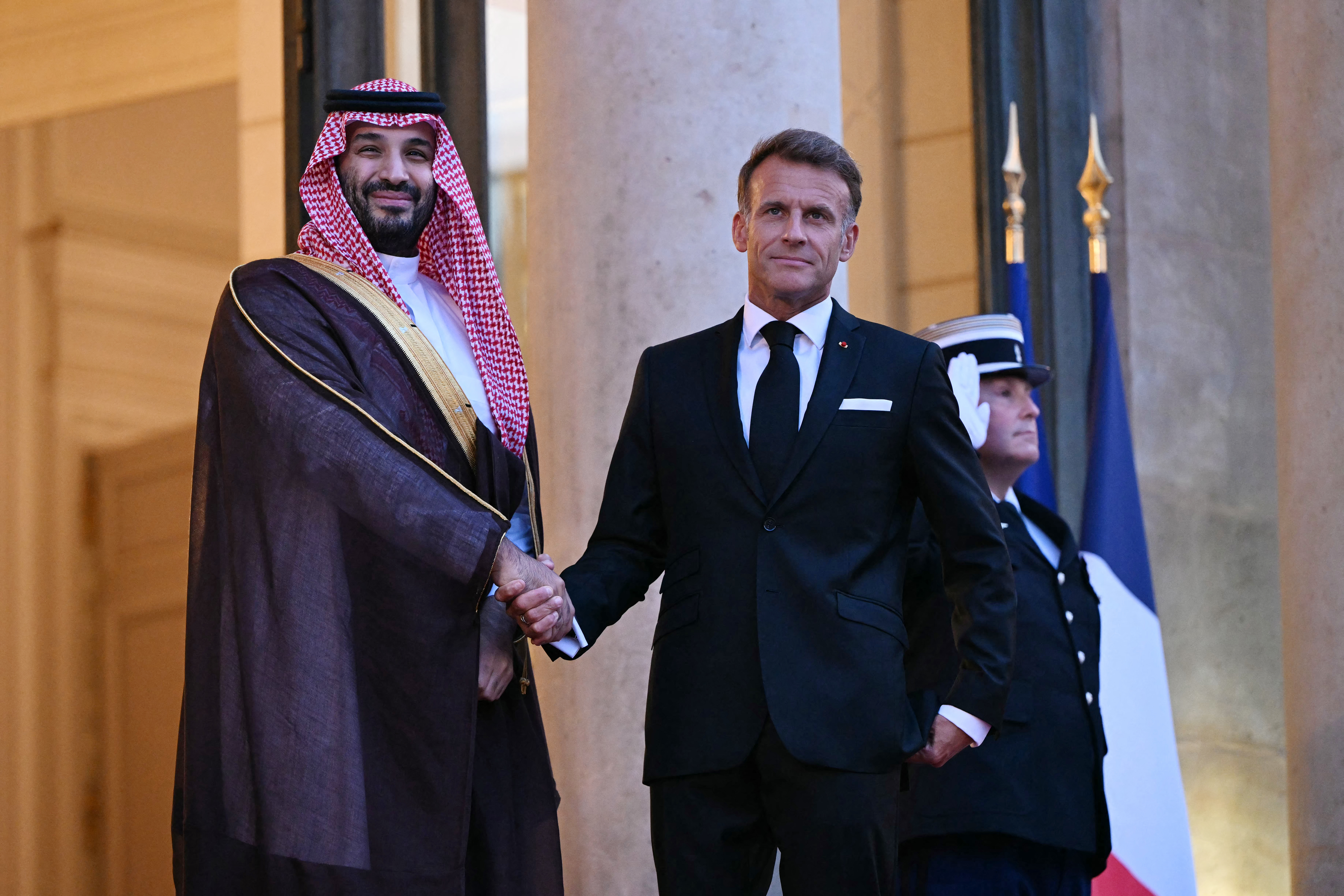 France's President Emmanuel Macron (R) welcomes Saudi Arabia's Crown Prince Mohammed bin Salman as he arrives for a State diner in his honour at the Elysee Palace in Paris on August 24, 2026. (Photo by LOU BENOIST / AFP)