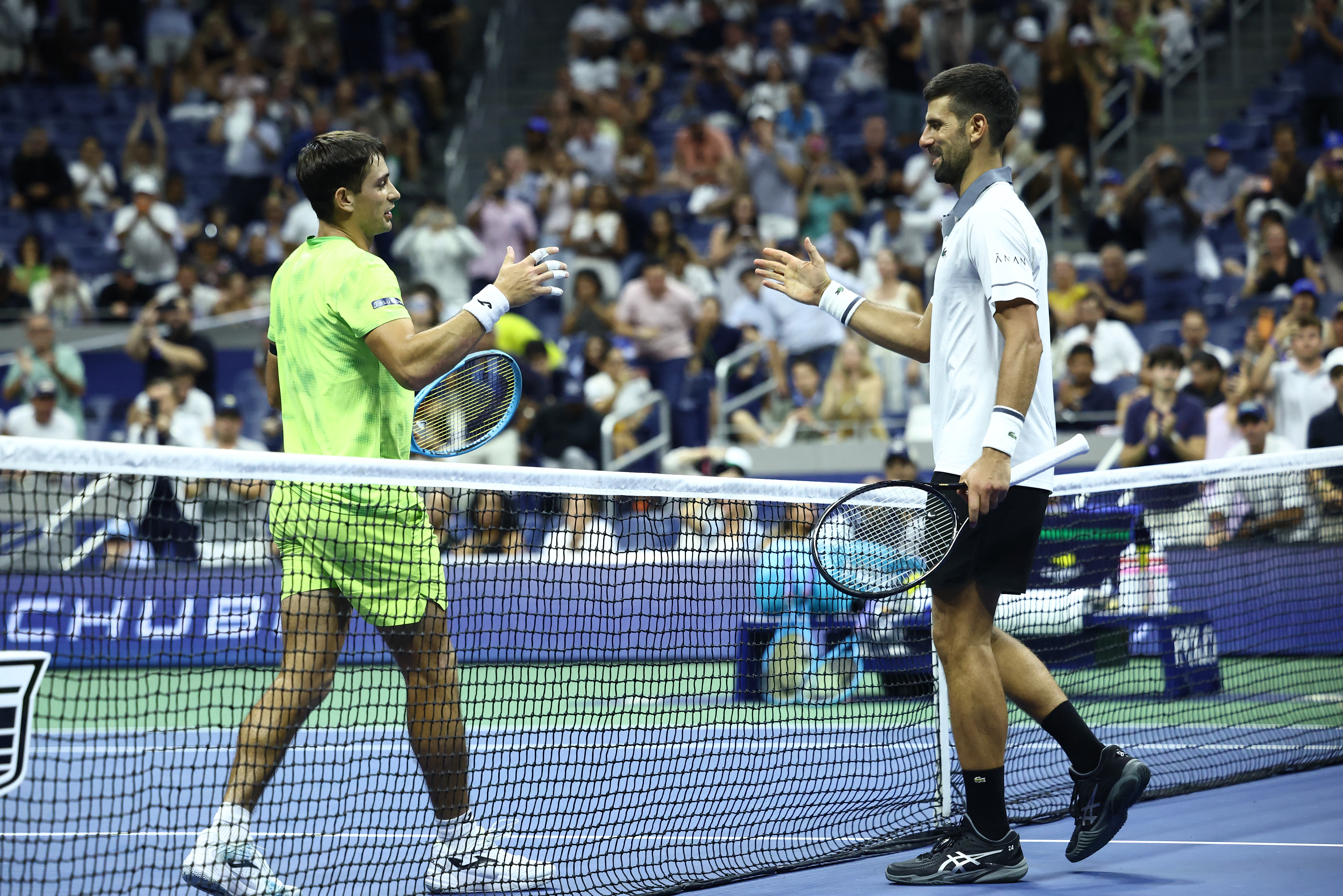 Serbia's Novak Djokovic (R) congratulates Argentina's Mariano Navone after losing the match during the men's singles first round tennis match on day one of the US Open tennis tournament at the USTA Billie Jean King National Tennis Center in New York City on August 30, 2026. (Photo by CHARLY TRIBALLEAU / AFP)