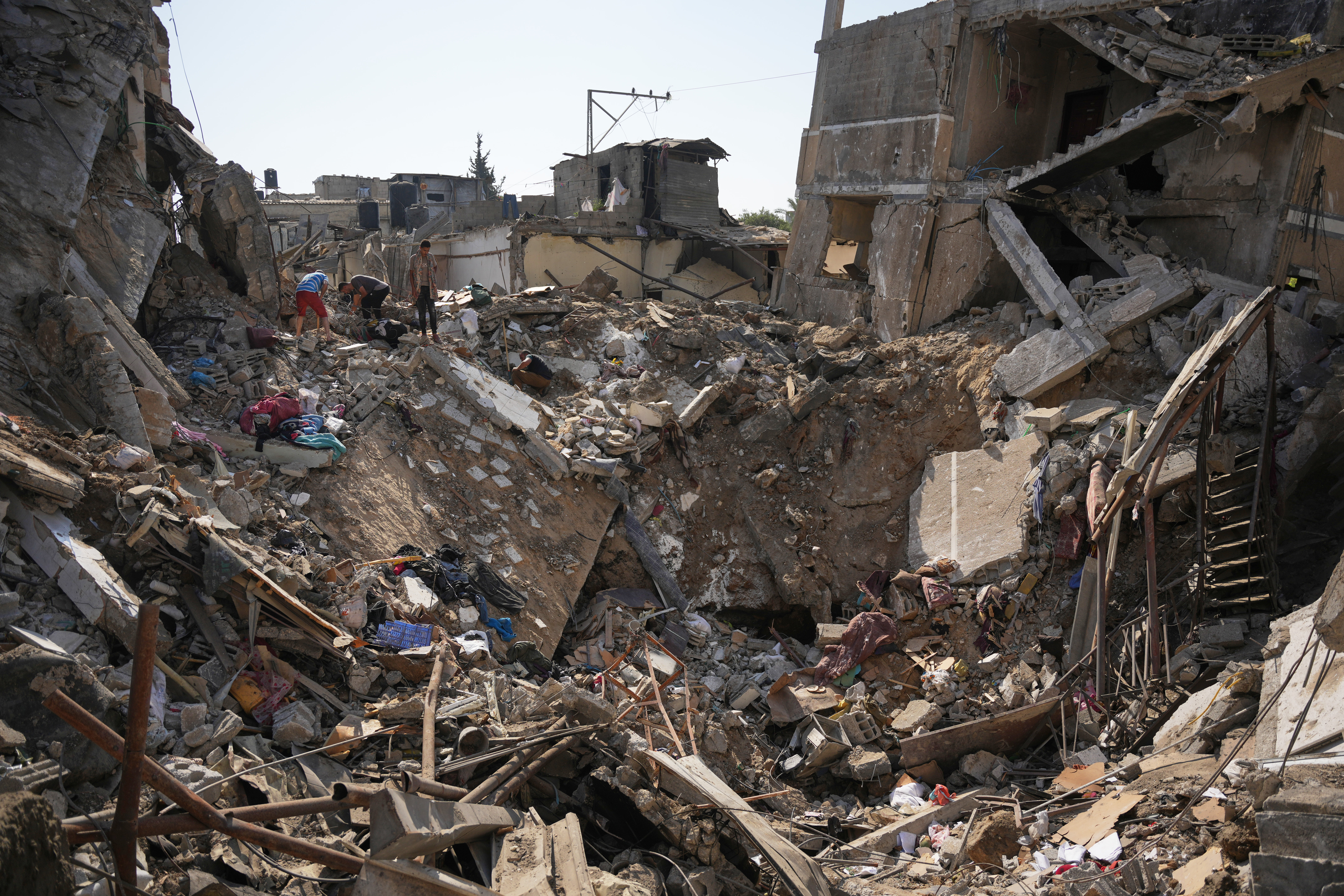 Palestinians save belongings from destroyed buildings at the scene of an Israeli air attack at the Maghazi refugee camp in Gaza Strip