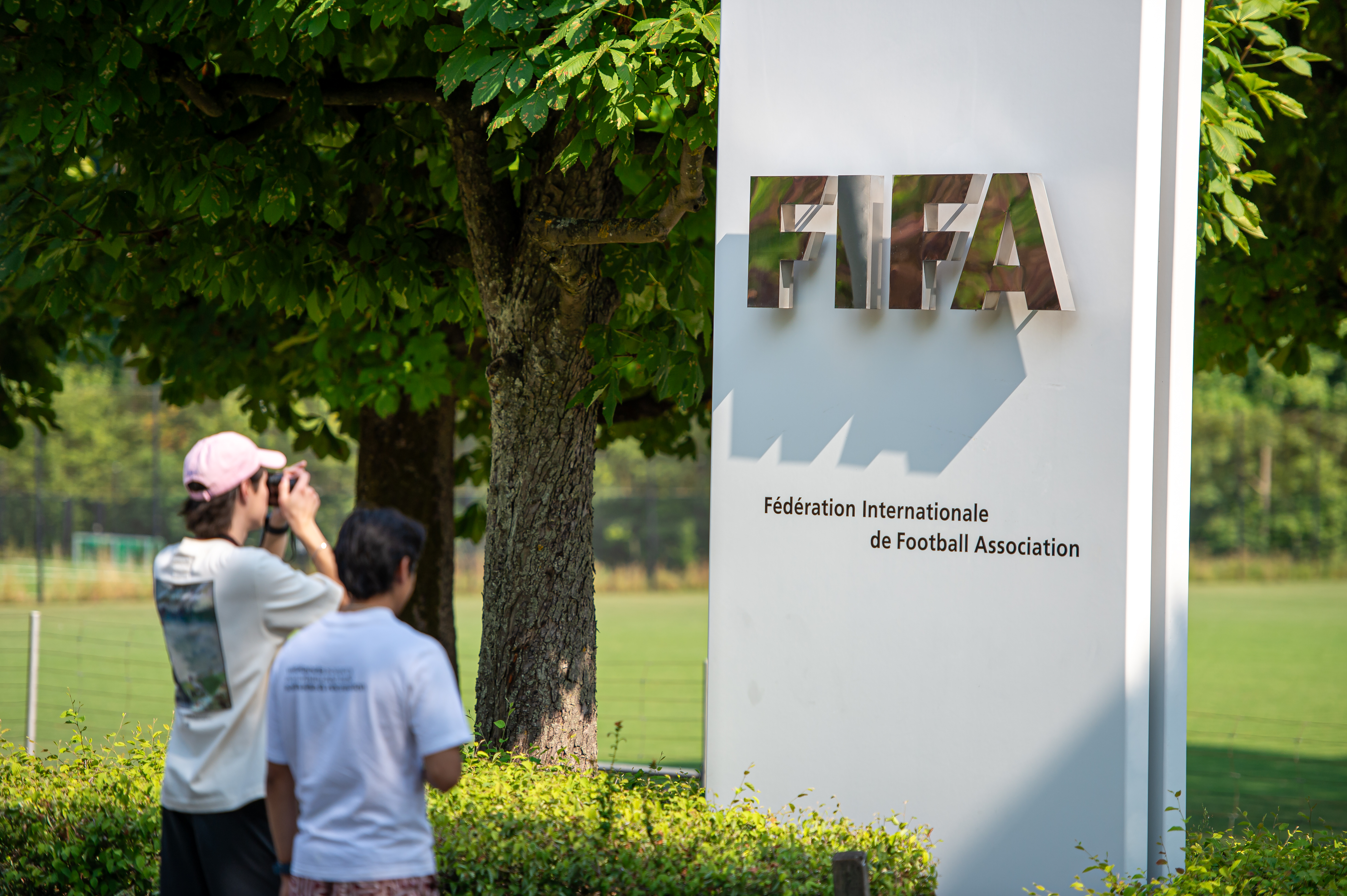 Football fans photograph a FIFA logo outside FIFA (Fédération Internationale de Football Association) global headquarters on July 30, 2026 in Zurich, Switzerland [Photo: Robert Hradil/Getty]
