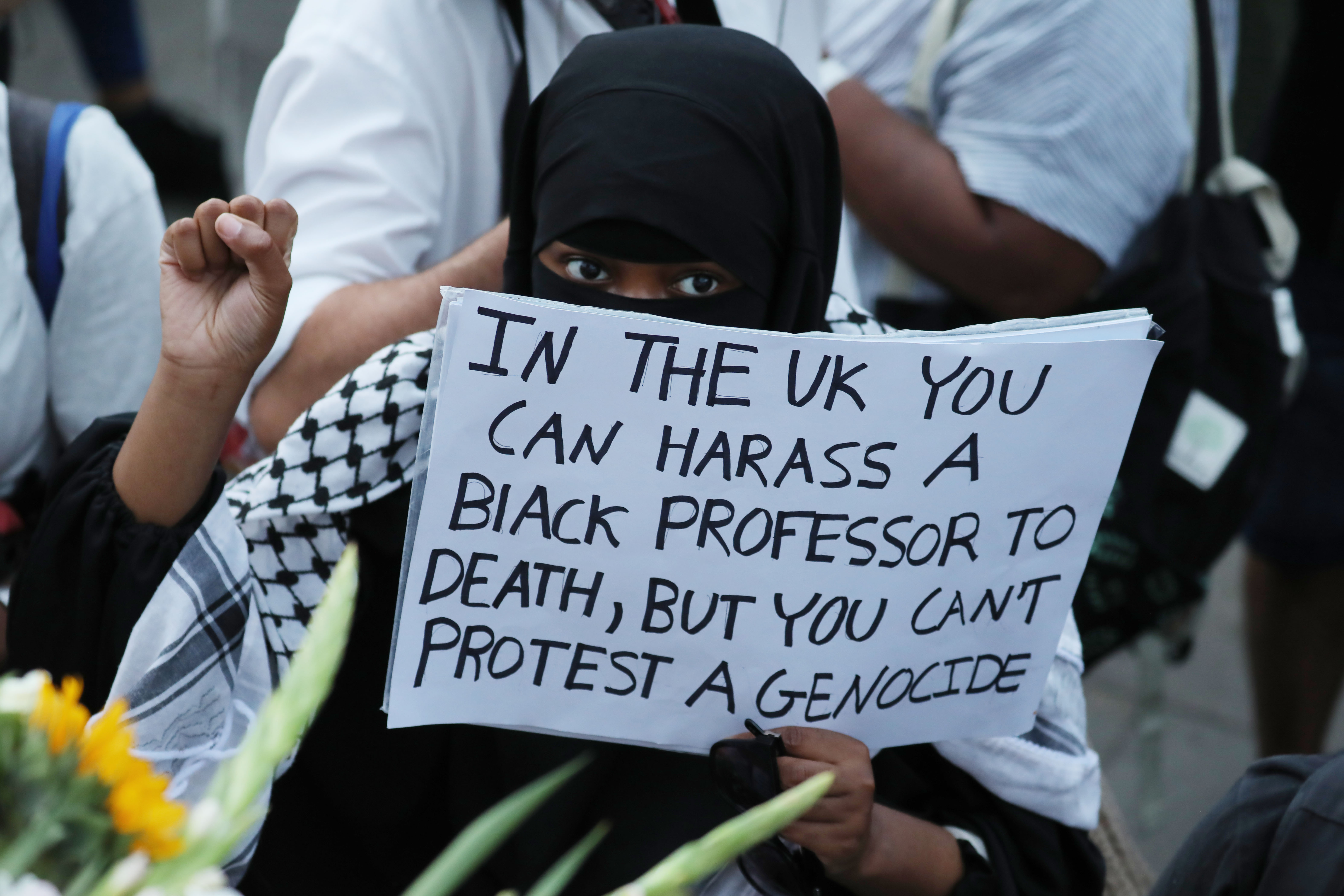 LONDON, ENGLAND - AUGUST 17: An attendee holds a placard during a vigil for former Cambridge professor Jason Arday in Trafalgar Square on August 17, 2026 in London, United Kingdom. Arday, 41, was found dead at his home in London on August 14, days after he resigned from his position as professor of sociology of education at Cambridge, amid accusations of plagiarism, which he denied. The vigil was organized by the campaign group Stand Up to Racism, which has said Arday's death was the "result of a racist witch-hunt." At age 37 Arday was the youngest ever Black professor appointed at the University of Cambridge. The British institution is facing criticism over it's handling of Arday's appointment and subsequent resignation. (Photo by Alishia Abodunde/Getty Images)