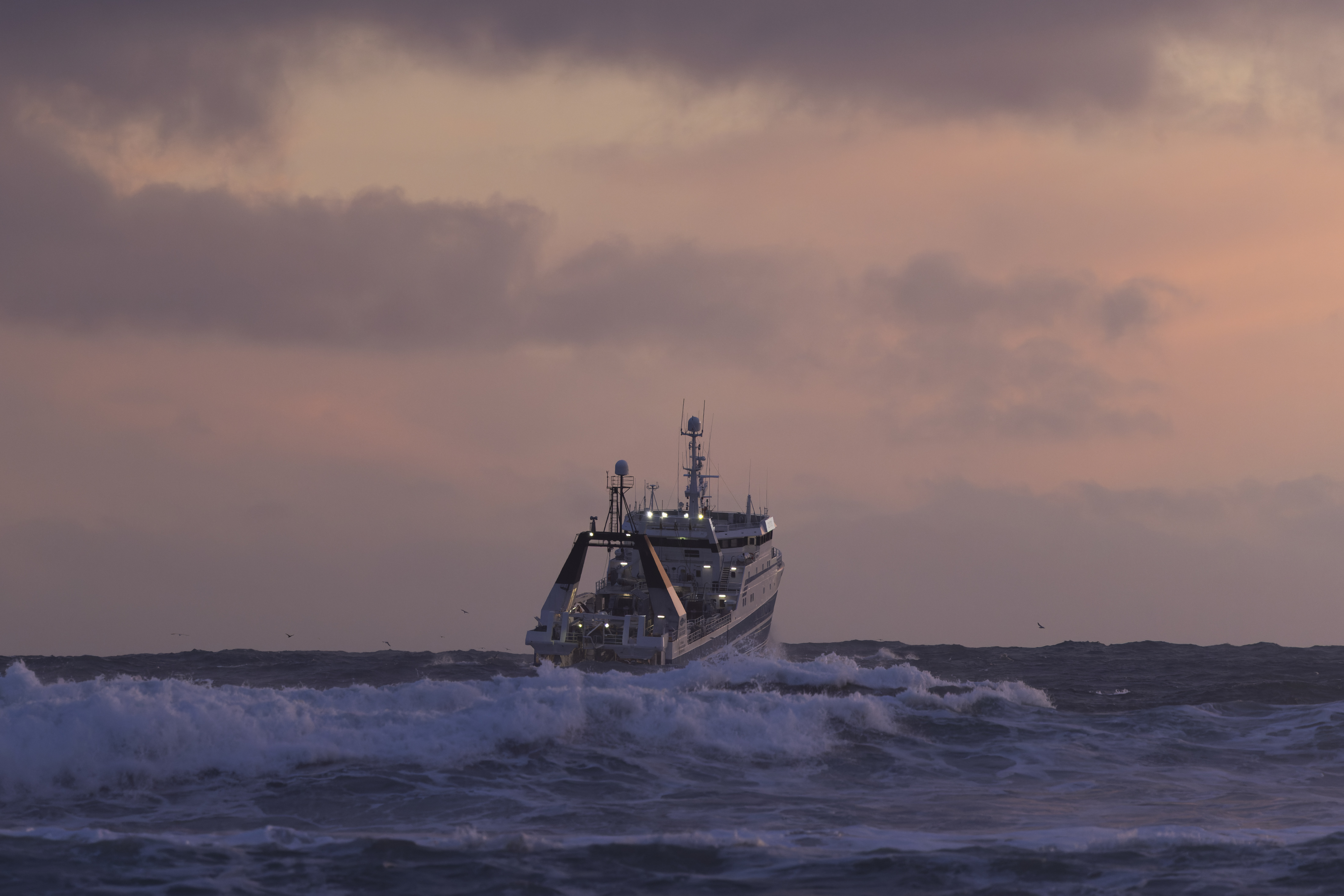 GRINDAVIK, ICELAND - DECEMBER 20: A fishing boat battles rough seas on December 20, 2025 in Grindavik, Iceland. The town of Grindavík, about 50km southwest of the capital, Reykjavík, was home to roughly 3,700 people before repeated volcanic eruptions along the Sundhnúkur crater row first forced evacuations in November 2023. In January 2024, lava intrusions destroyed several houses after a fissure opened inside defensive berms, while a tectonic fissure cuts through the town. One worker was killed after falling into the fissure during repairs. The Svartsengi power plant and Blue Lagoon lie just north, directly above accumulating magma, with both facilities crucial for Iceland's economy and tourism. The most recent eruption ended in August 2025, but the Icelandic Meteorological Office warns that "life-threatening conditions remain" and "an eruption is considered likely." The fishing community has since partially reopened, with limited services. Despite warnings, some residents have returned, as debate continues over the town's future. (Photo by Brook Mitchell/Getty Images)